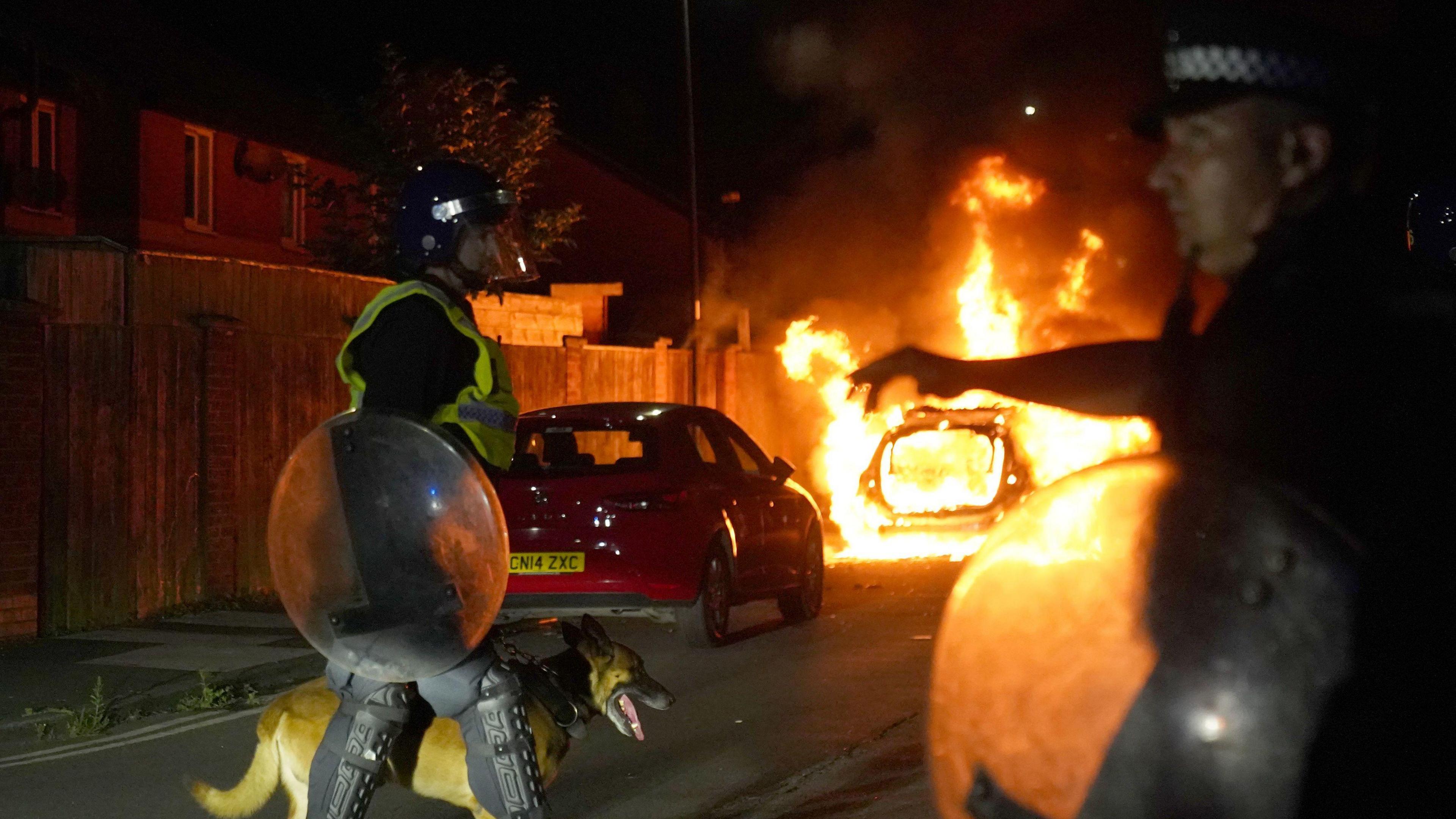 A police car burns as officers are deployed on the streets of Hartlepool following a violent protest