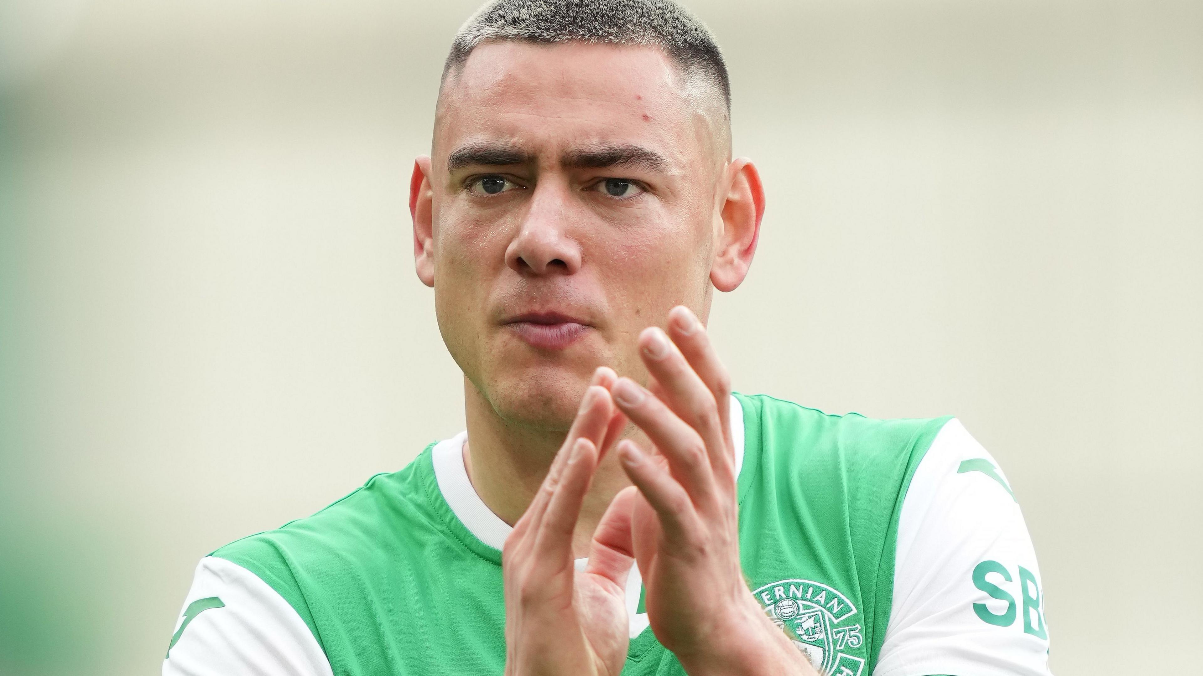Lewis Miller applauds the Hibernian supporters