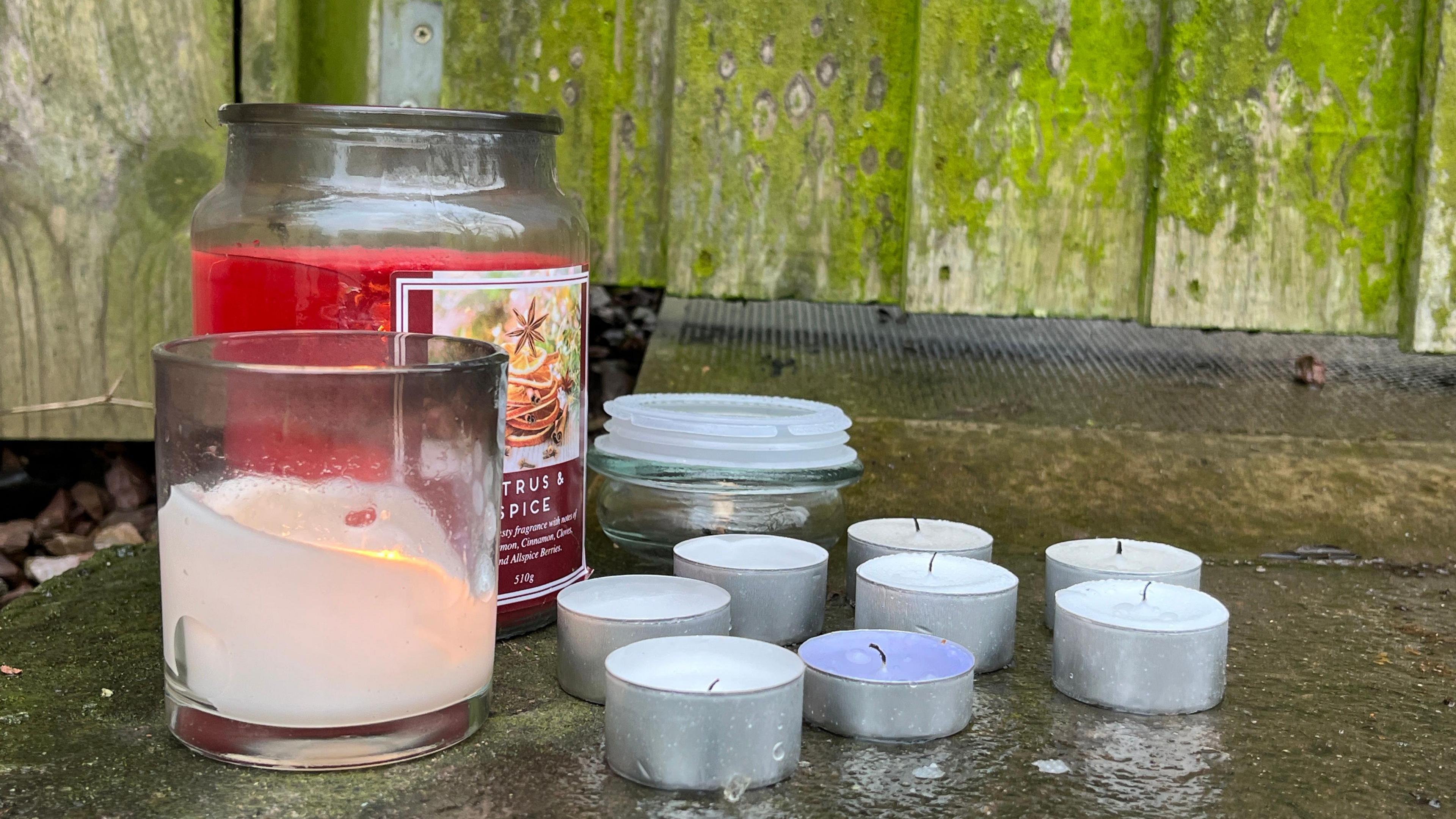 Candles at the scene. There are two large Yankee-style candles and a number of fairy-type candles. 