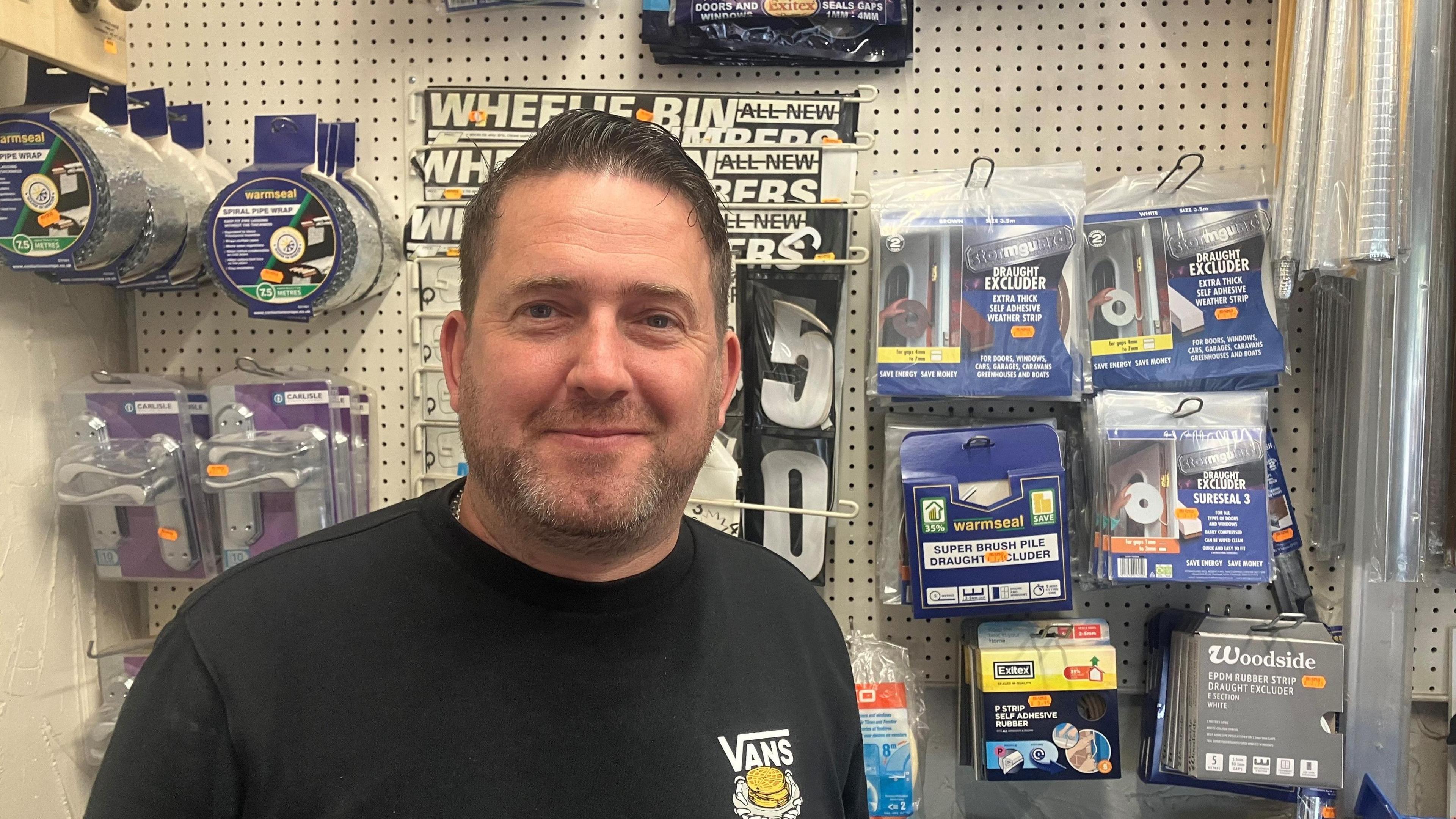 Mark Walker in his shop in front of DIY items