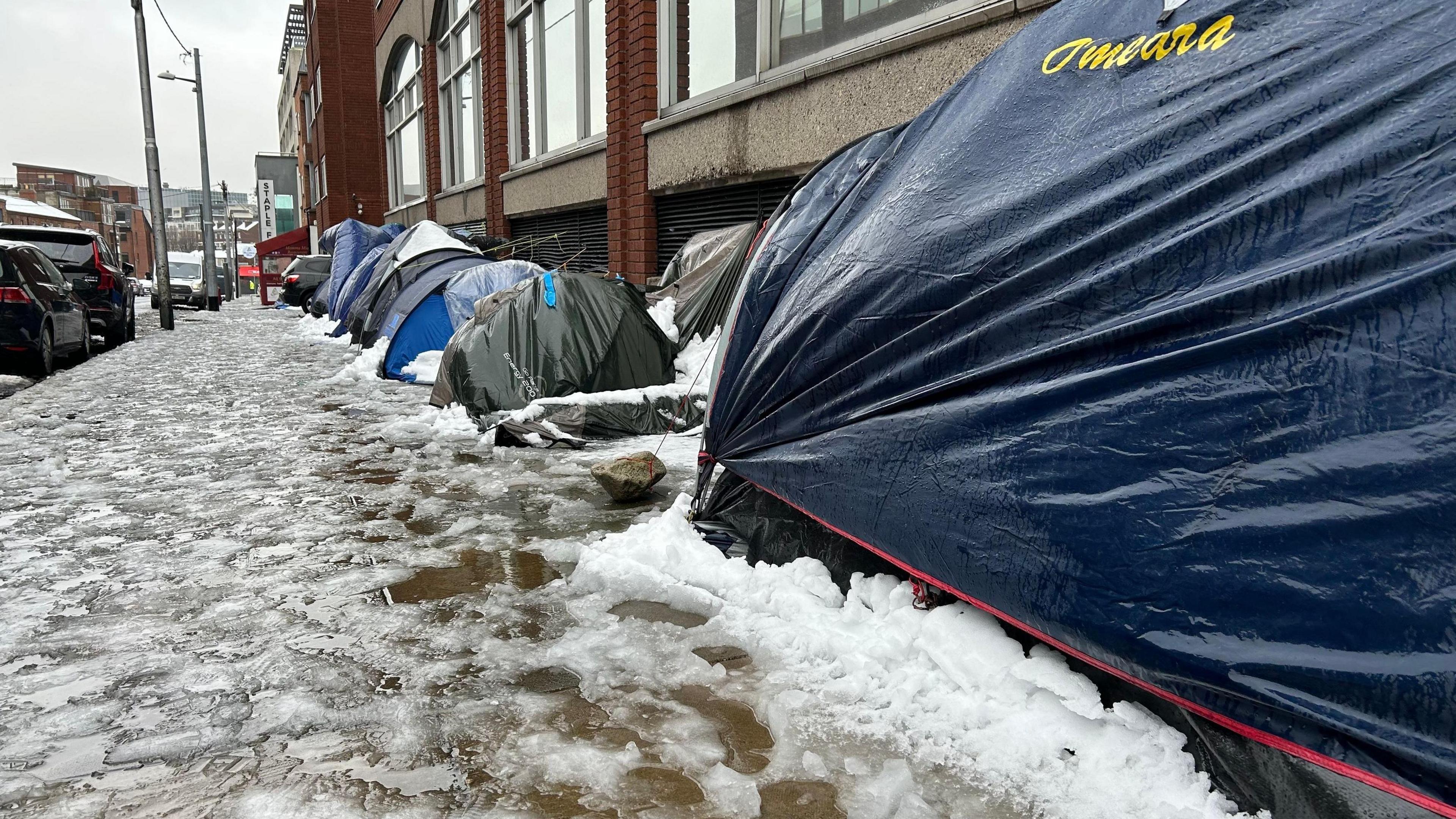 Tents, some flooded and collapsed, used by migrants and other people experiencing homeless outside the International Protection Office during a period of snow in Dublin