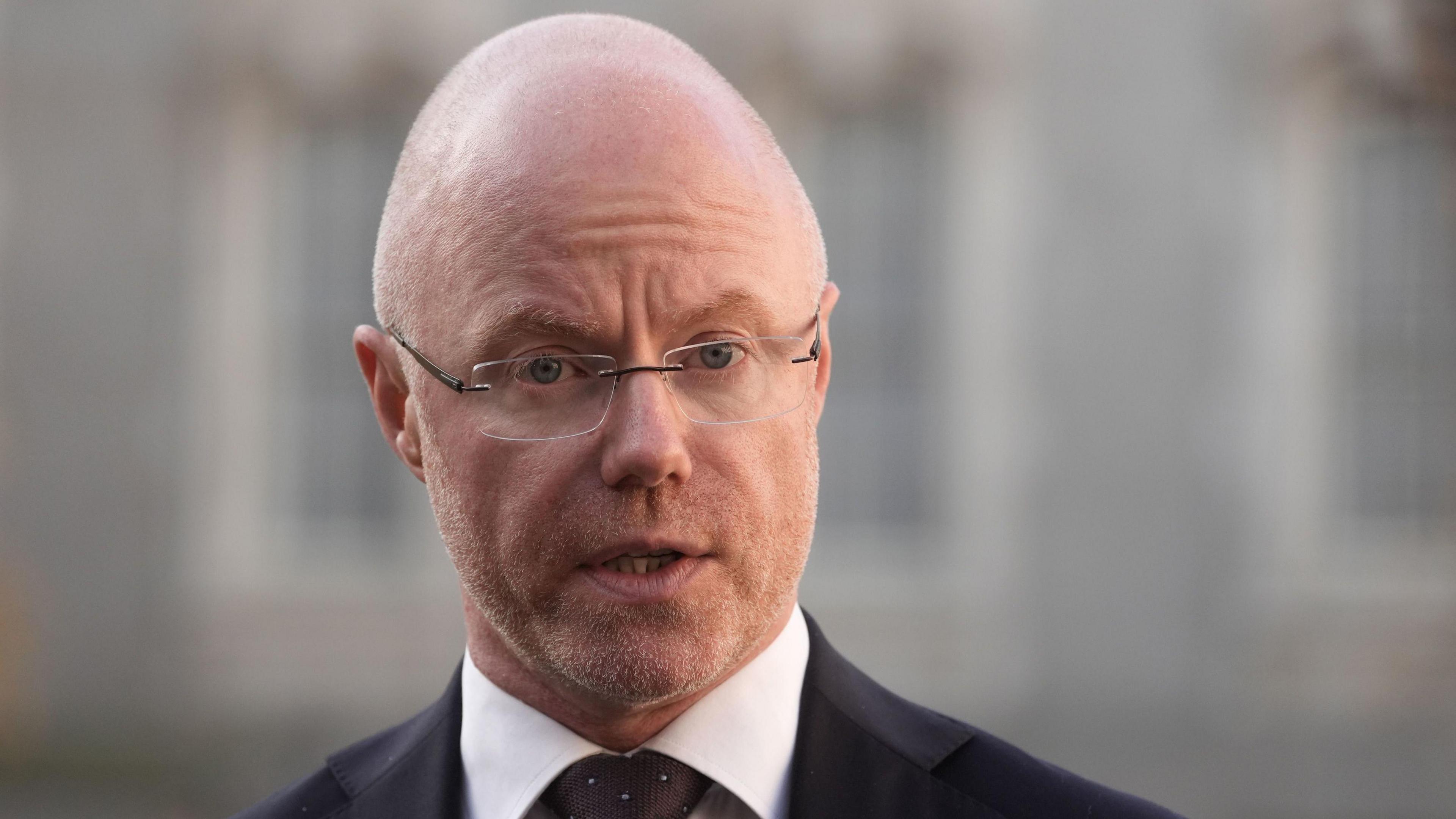 Headshot of Stephen Donnelly looking at the camera wearing a suit and tie