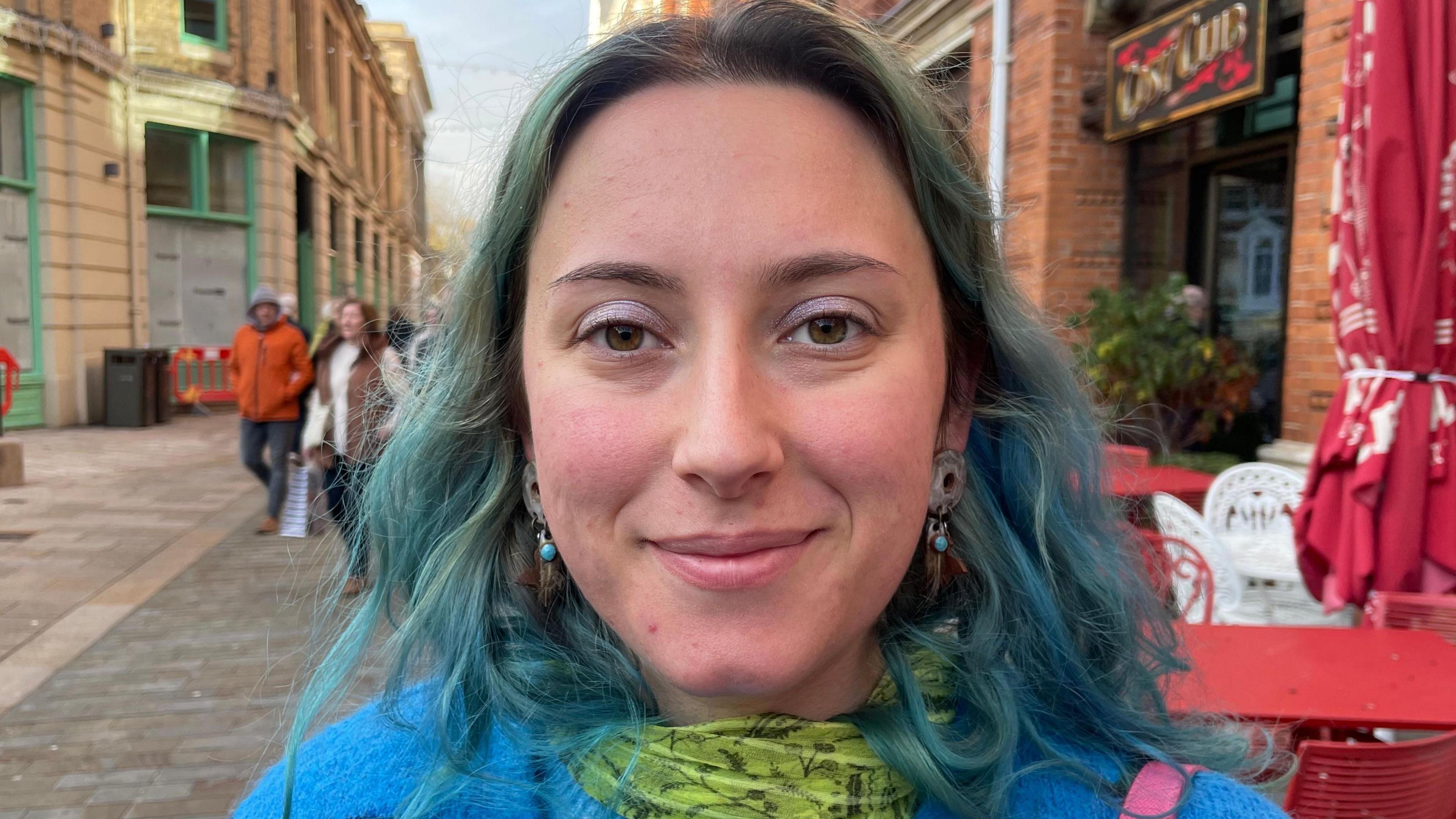 Young woman with blue hair smiles in Lincoln city centre