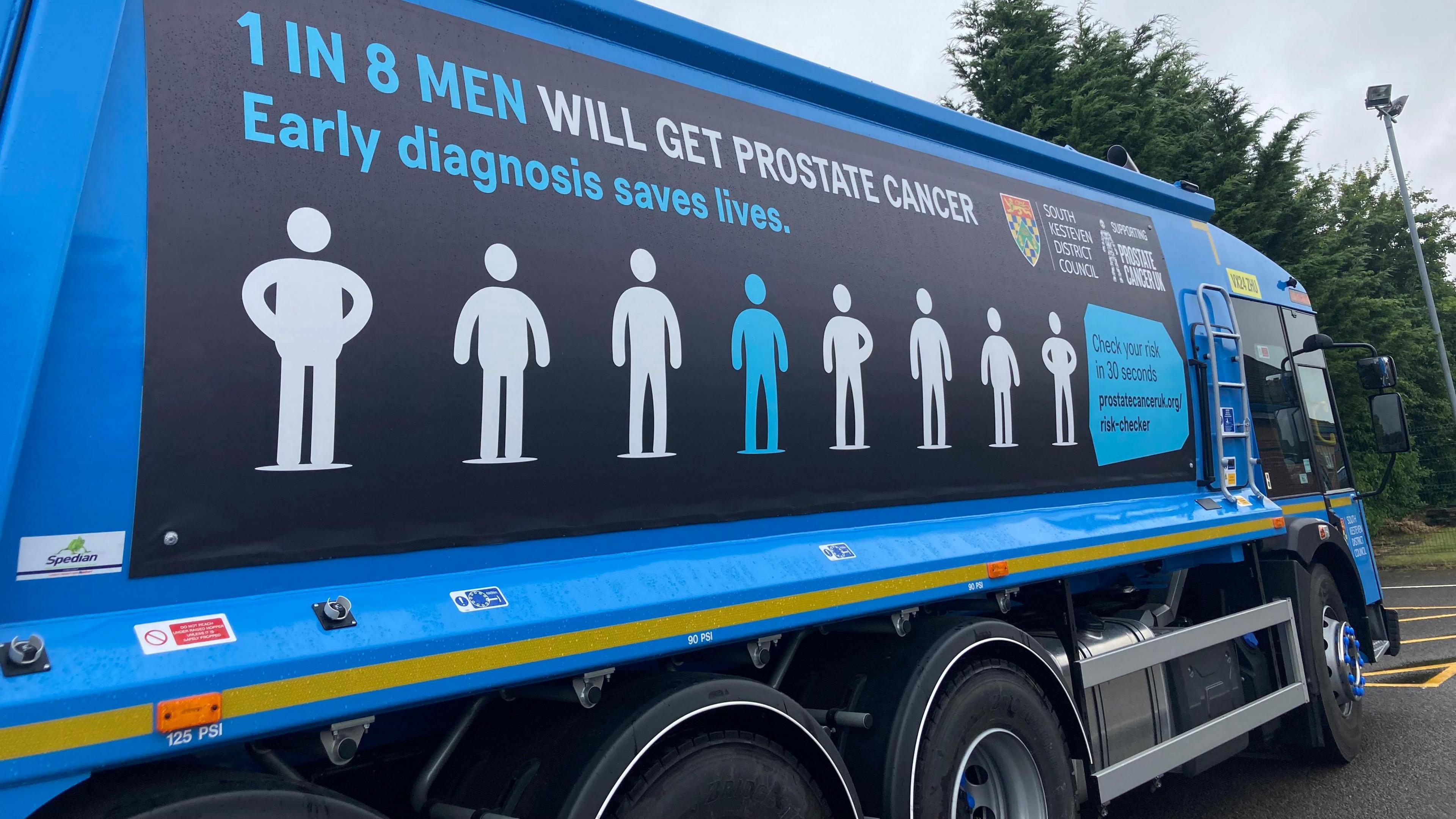 The blue bin lorry has a design showing the silhouettes of eight men, seven of them coloured white and one blue