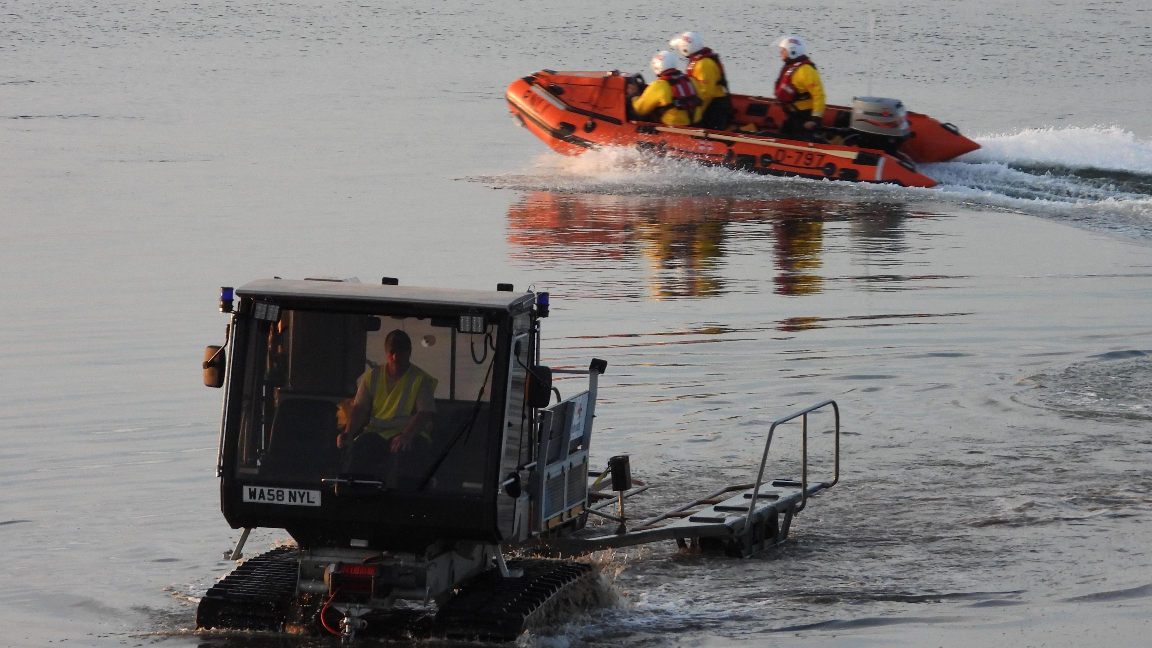 A lifeboat in the sea with three crew members on board.