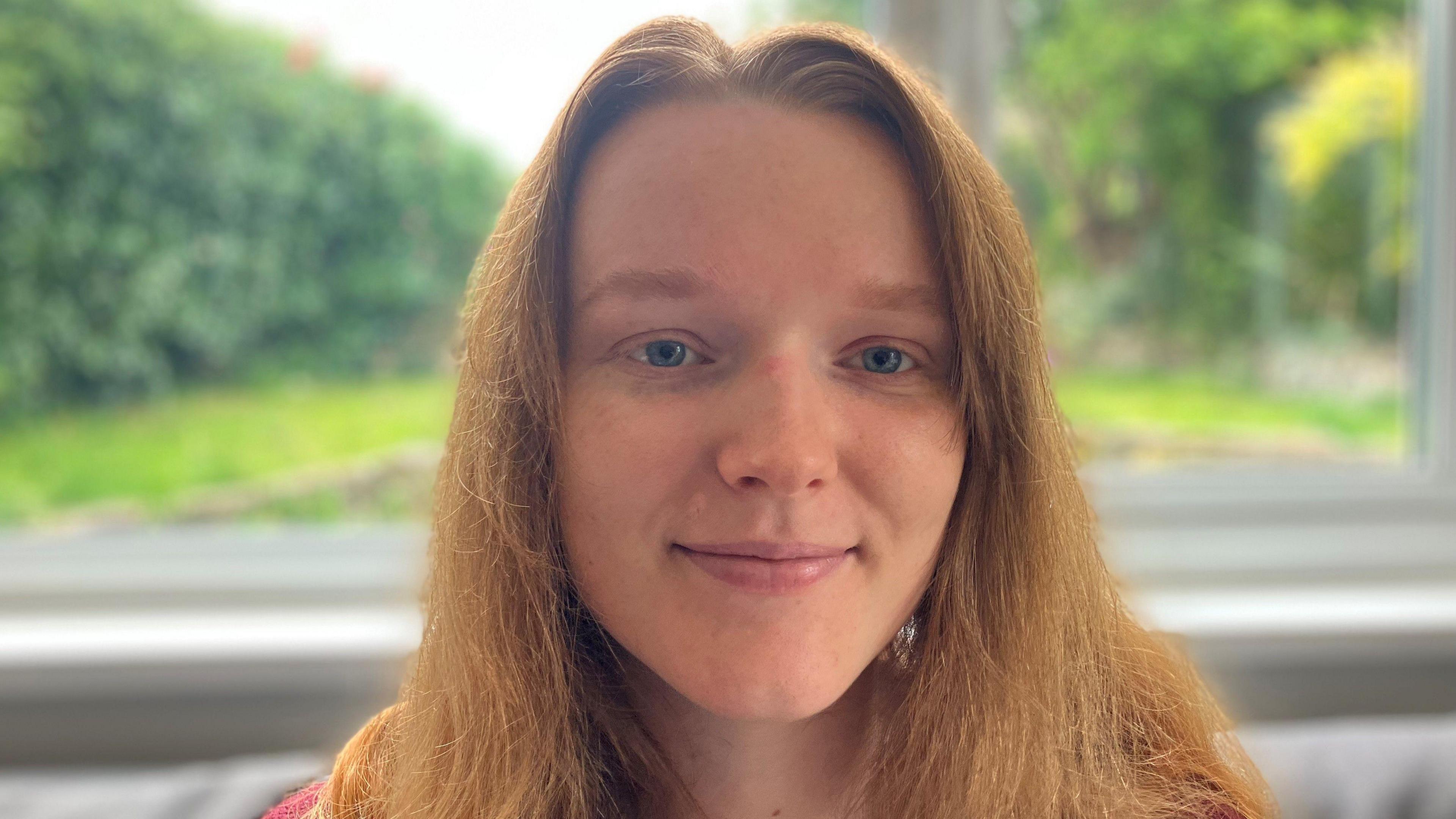 Girl with long red hair smiling at the camera