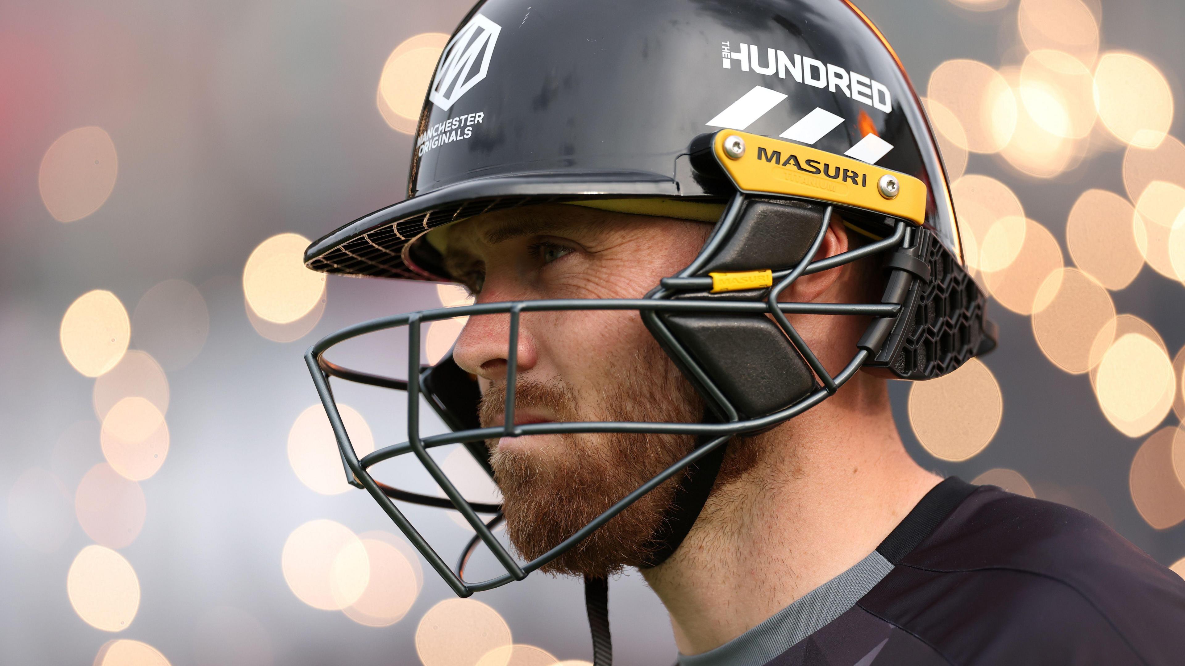 Close up of Phil Salt in a helmet with light effects behind him