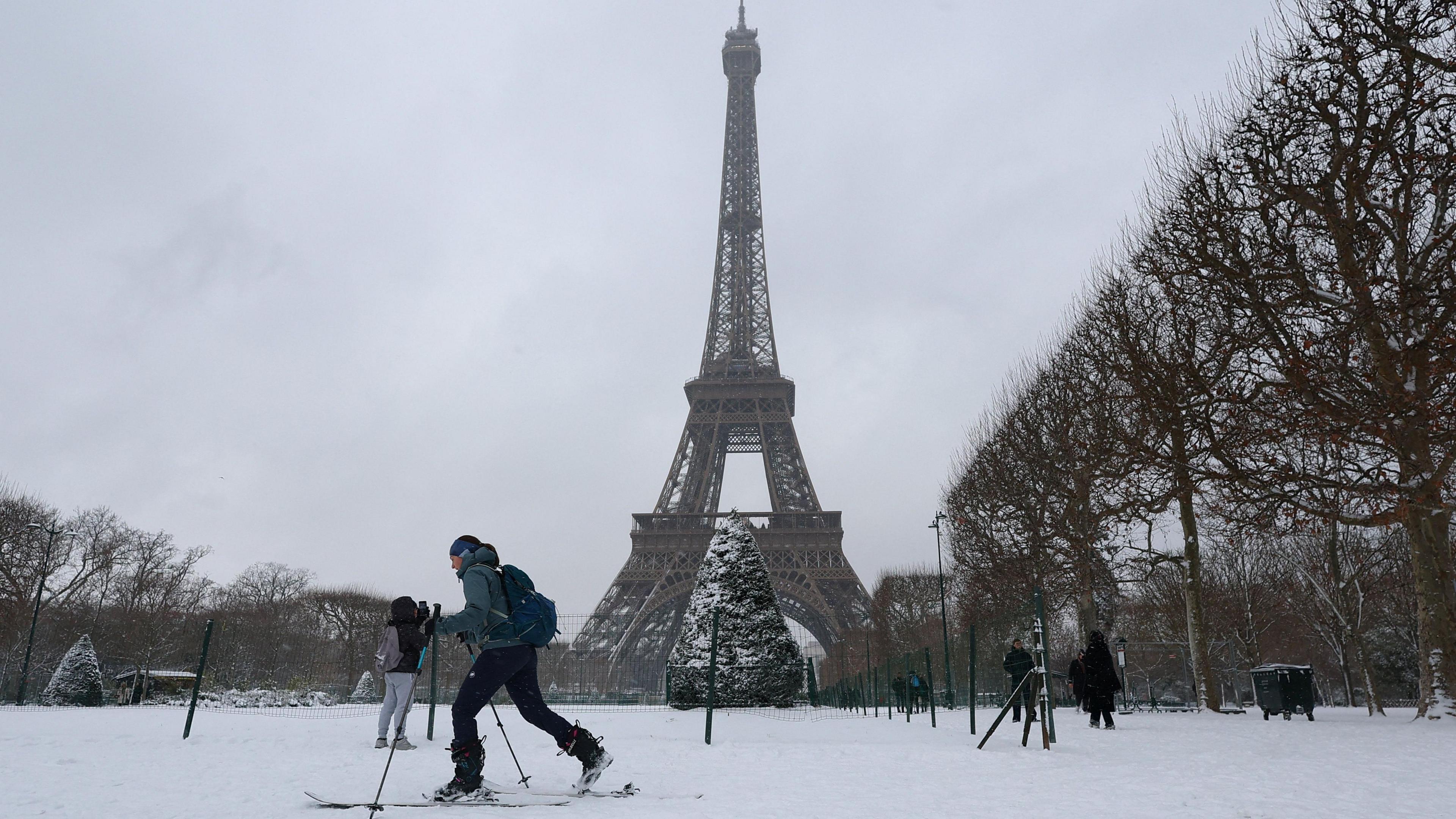 A man skiing in front of the Eiffel Tower.