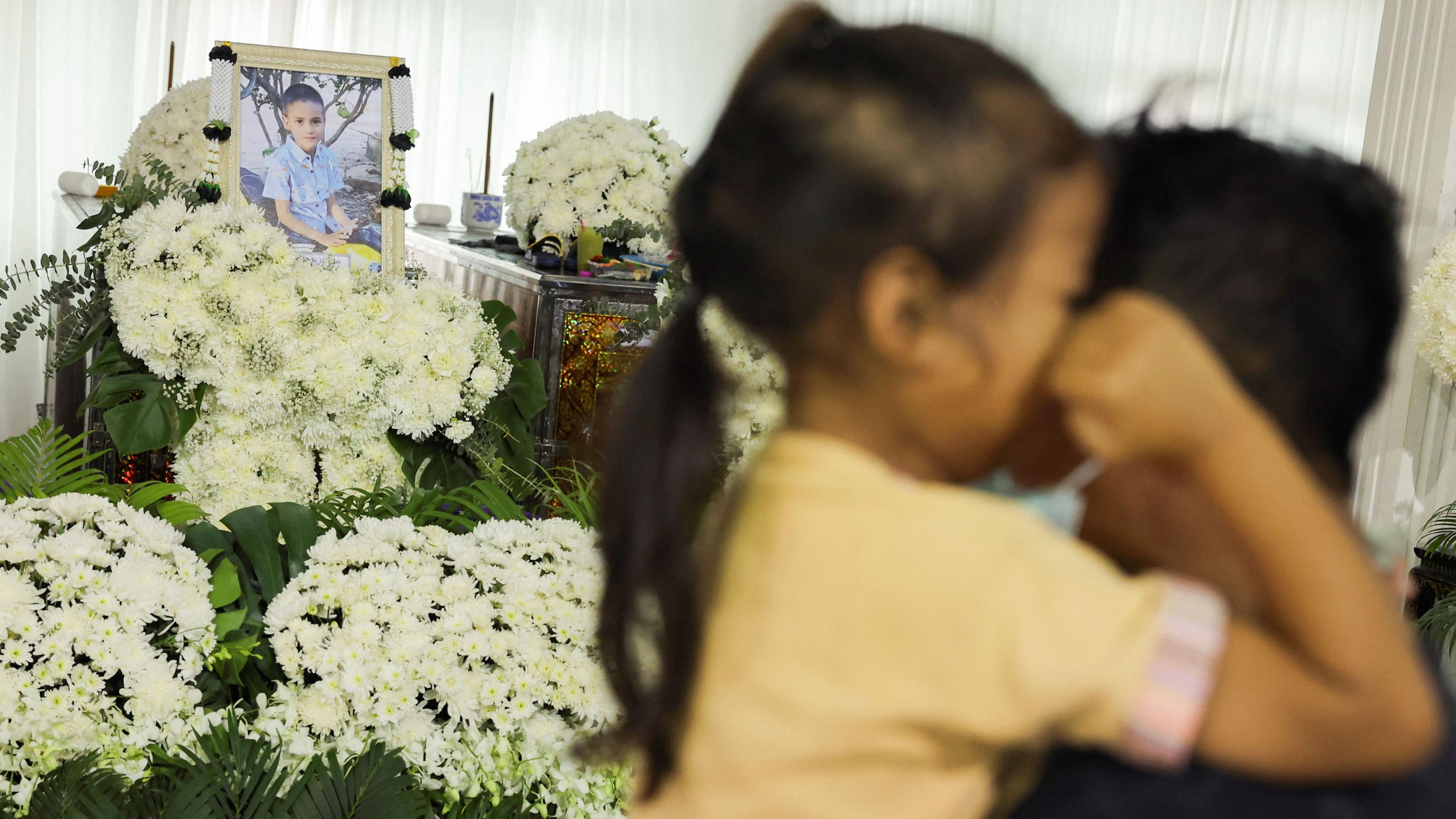 Family members react during a funeral of their child, Peerapat Phleedee, 9, who had been studying in Wat Khao Phraya School and was killed in a bus which was engulfed in a fire while on a school field trip in Bangkok, in Uthai Thani province, Thailand, October 3, 2024.