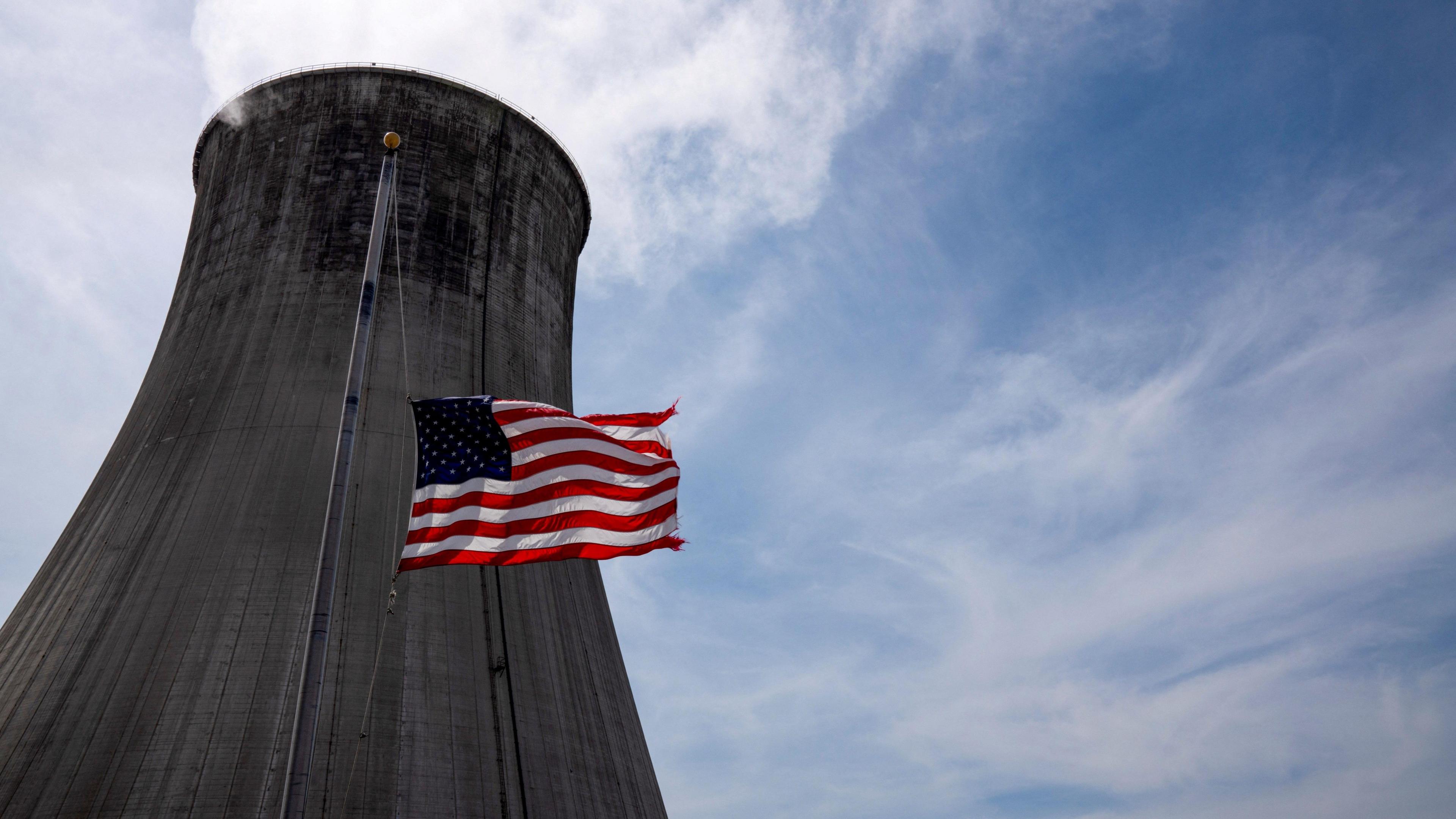 The US flag flies in front of a coal-fired power plant's cooling tower at Duke Energy's Crystal River Energy Complex in Crystal River, Florida