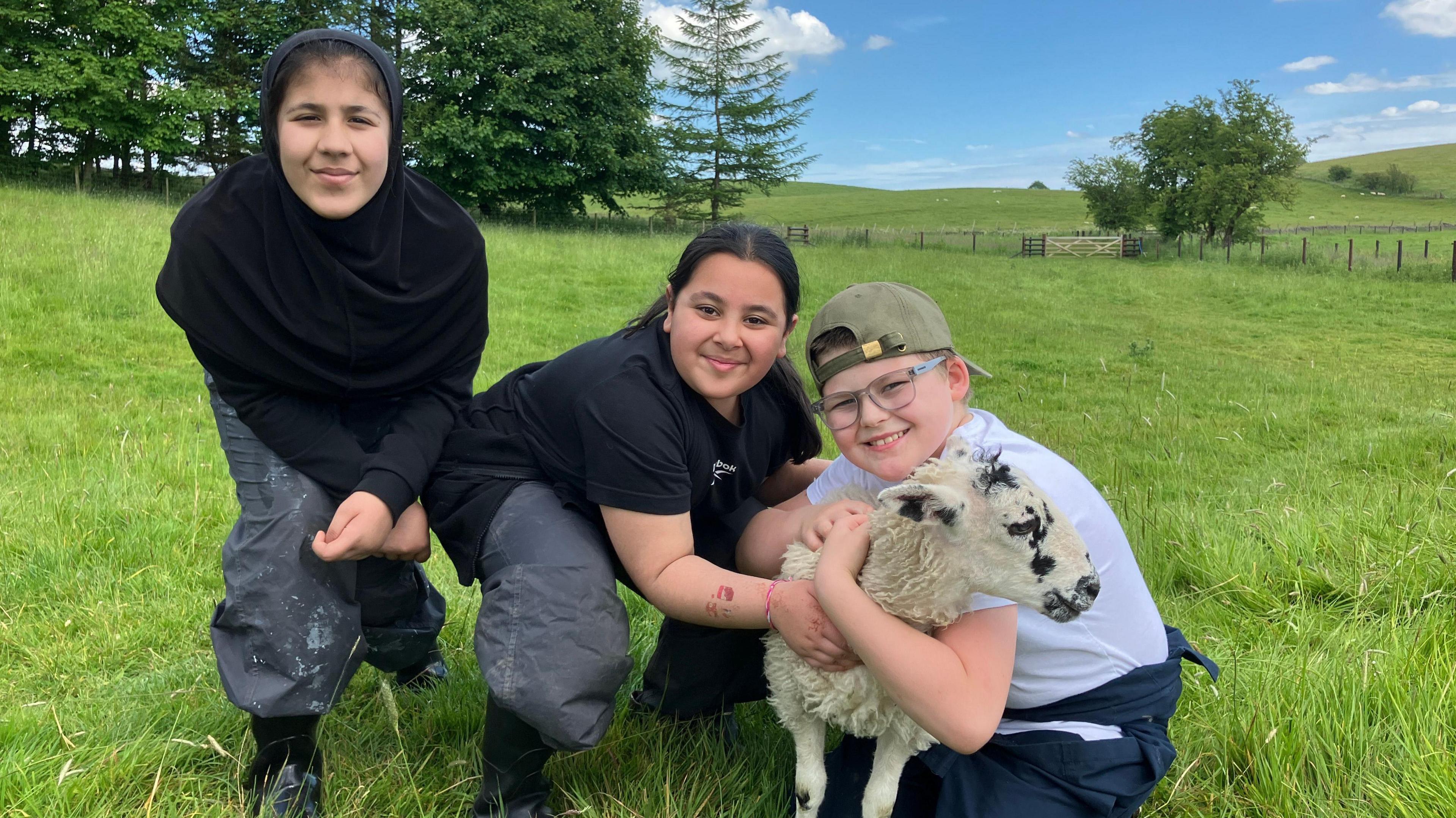 Three children with a lamb