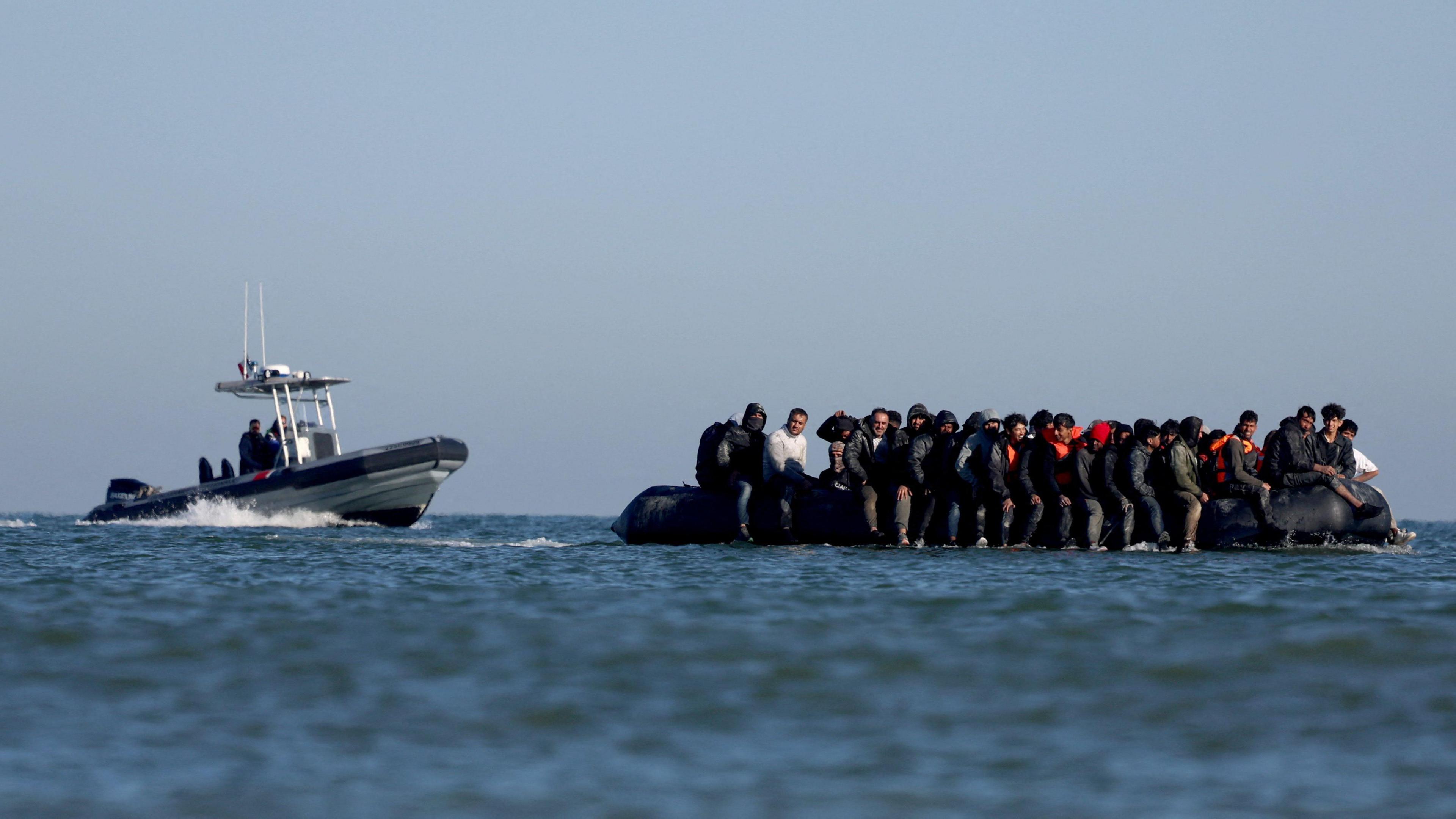 French gendarmes approach a boat of a group of people attempting to cross teh Channel to reach Britain in August.
