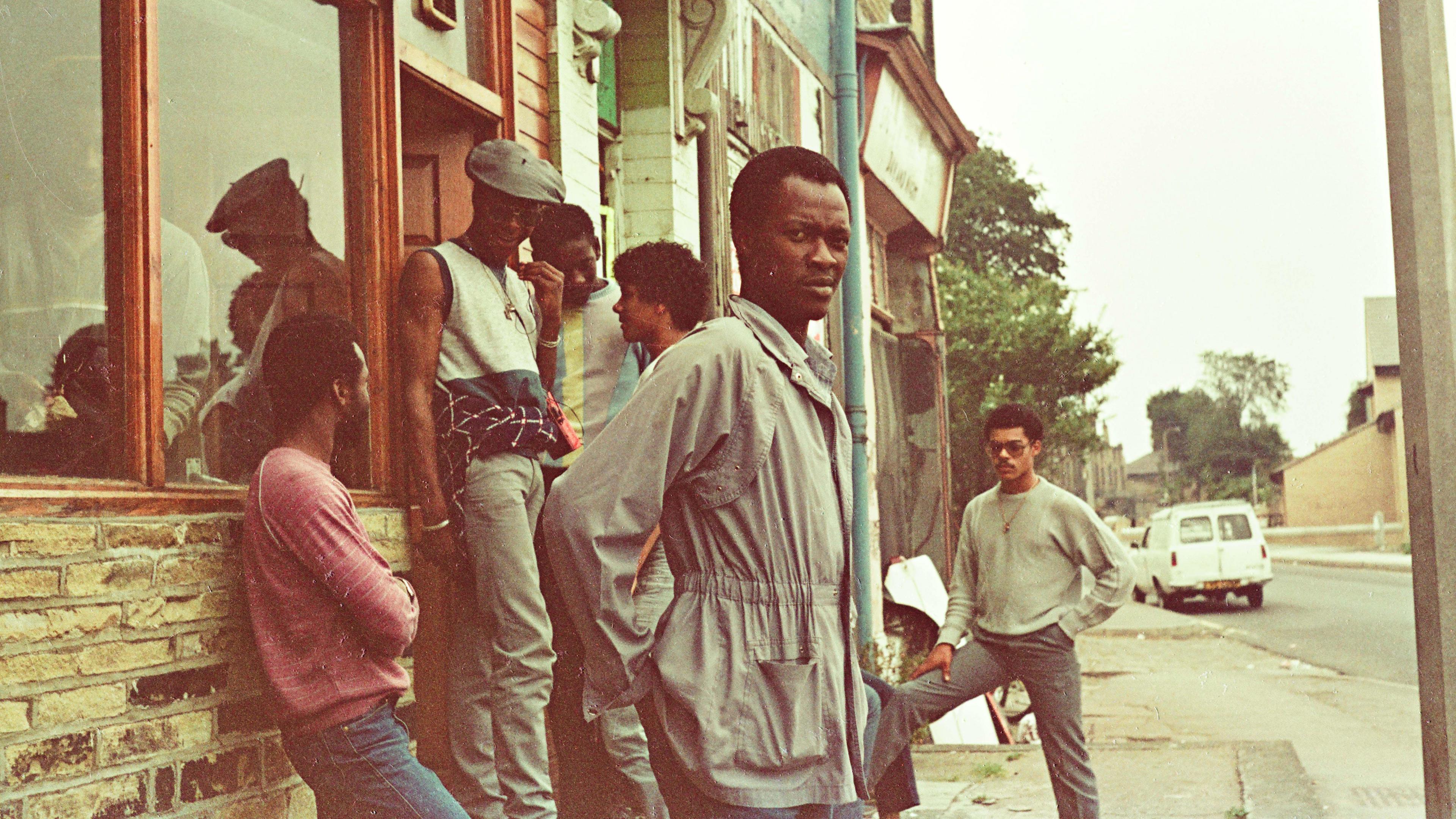 A group of men standing outside a cafe.