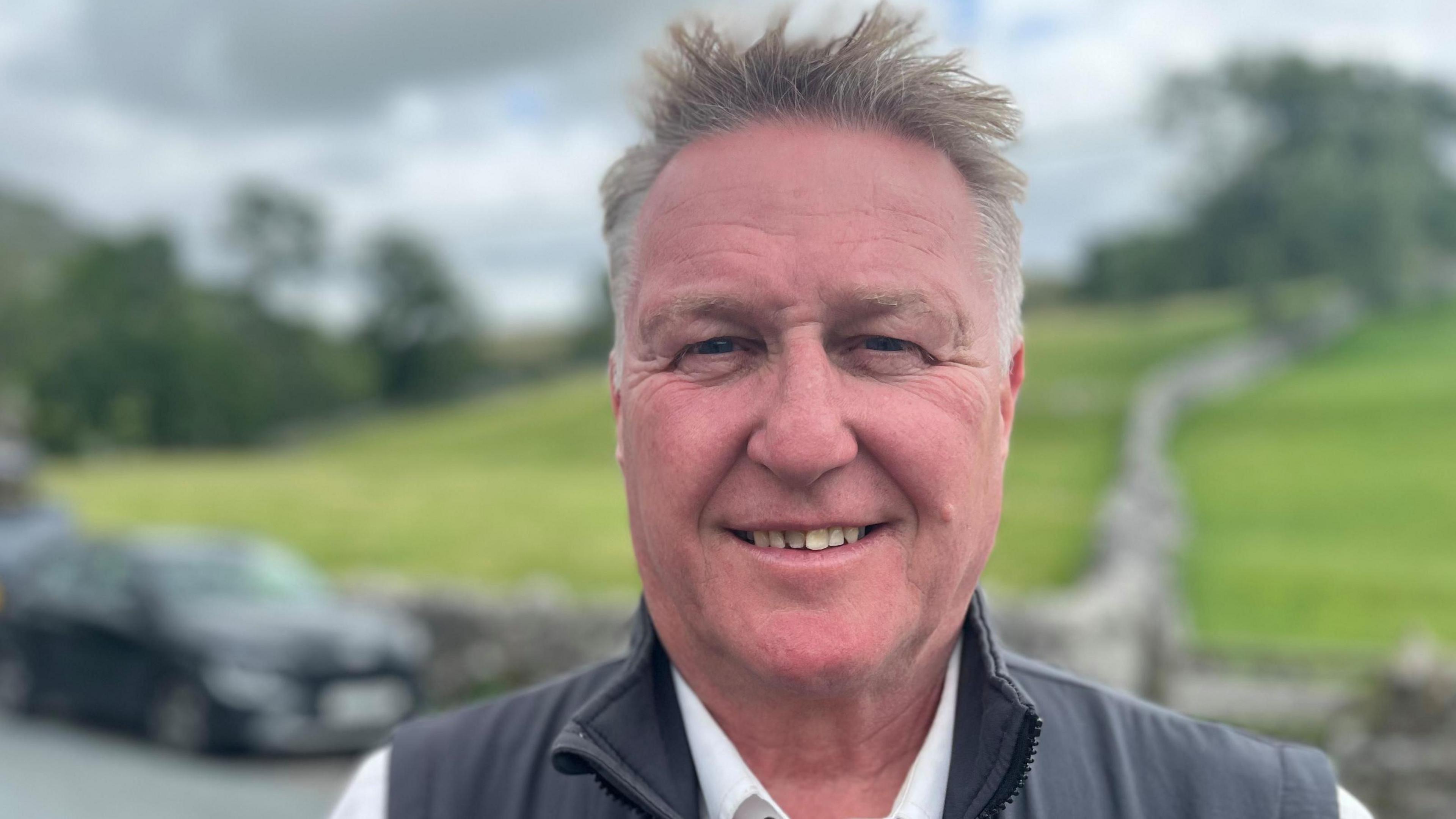 Simon Stephenson, who has spiky grey hair and blue eyes. He is smiling in the photo.