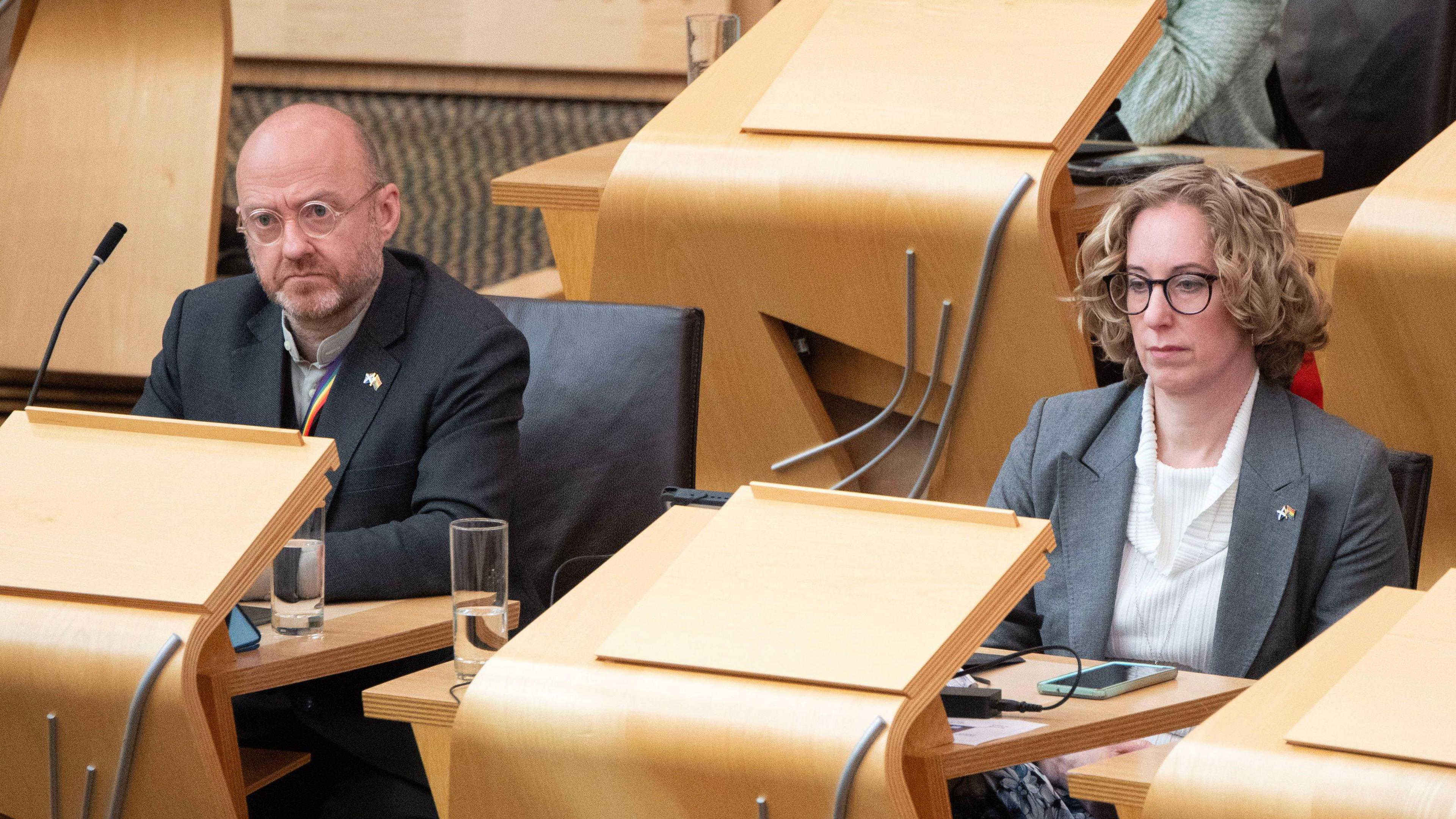 Patrick Harvie sitting beside each other in the Scottish Parliament chamber