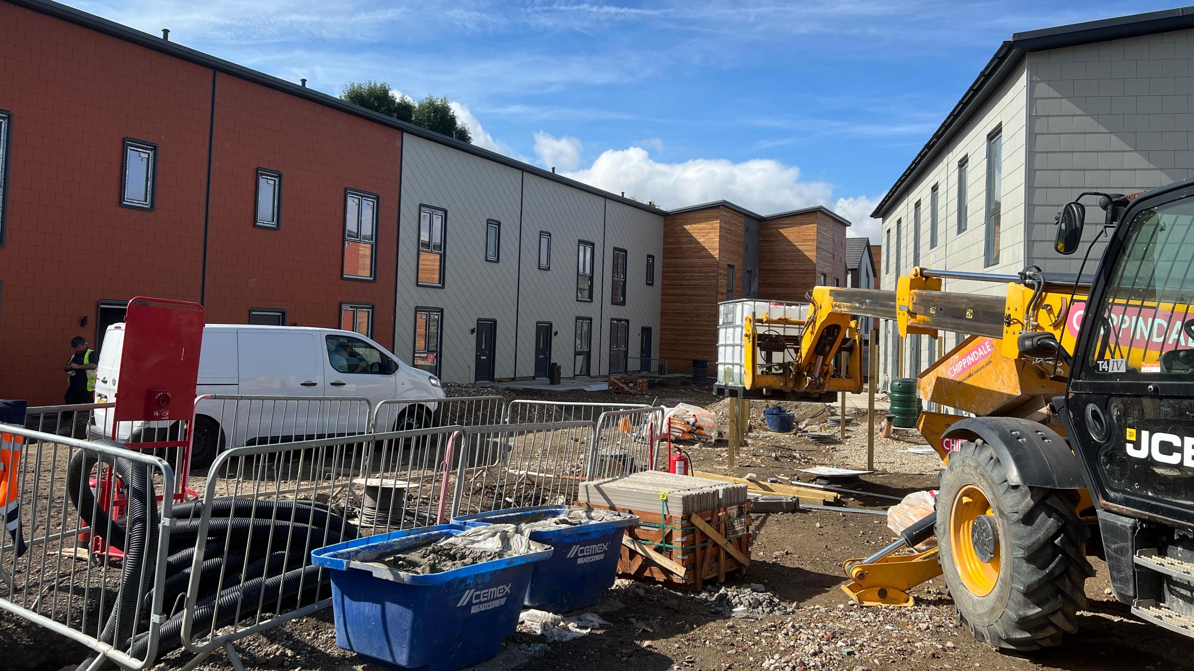 This is an image of work at the Yorspace community housing development at Lowfield Green, Acomb, York. A JCB is in the foreground, the part-finished homes in the background.