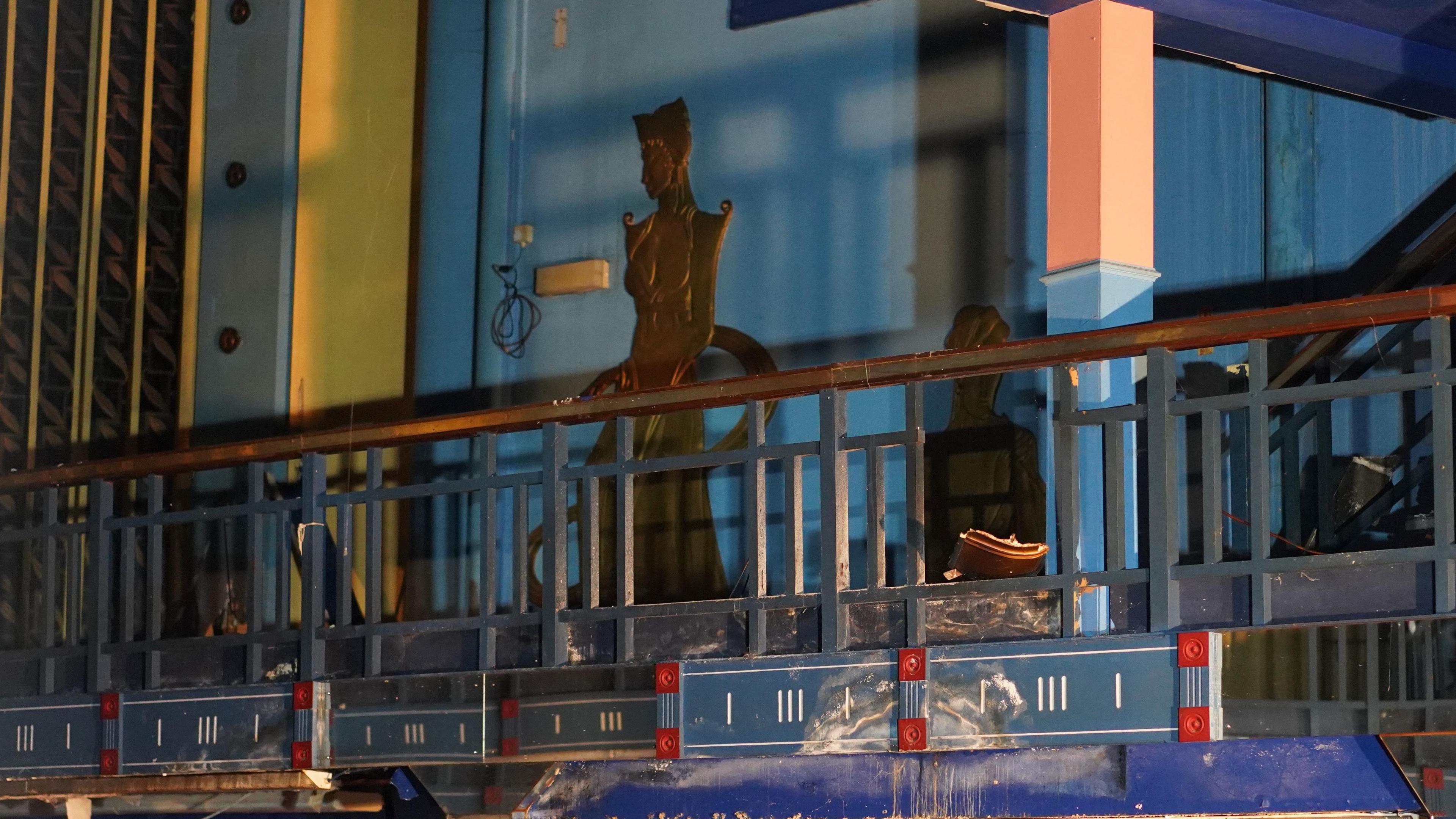 Shot of the mezzanine floor, there is a bronze coloured painting of a figure wearing Egyptian style dress.