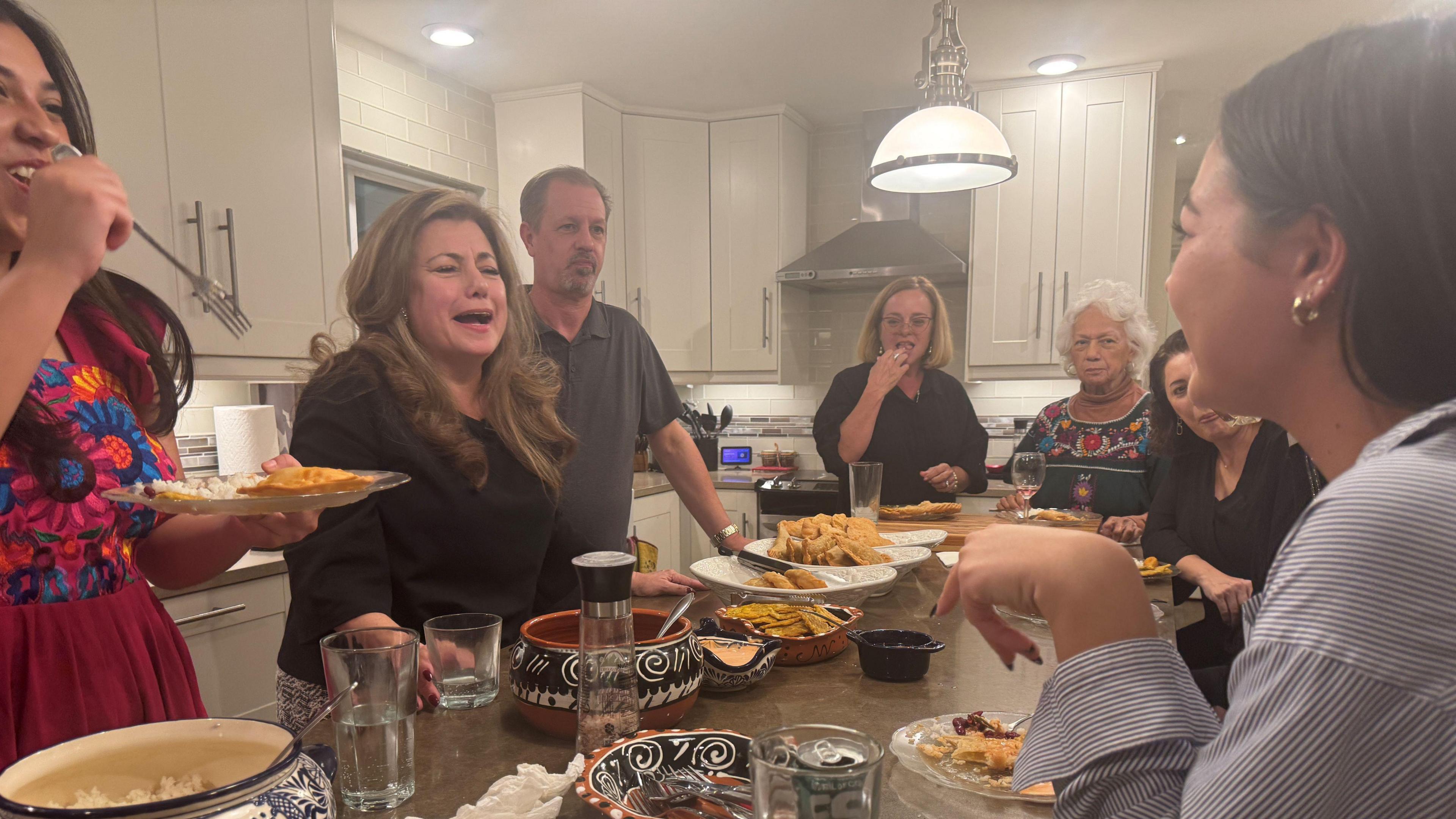 The Villalobos family eats dinner around an island inside a big kitchen in their Phoenix home. 