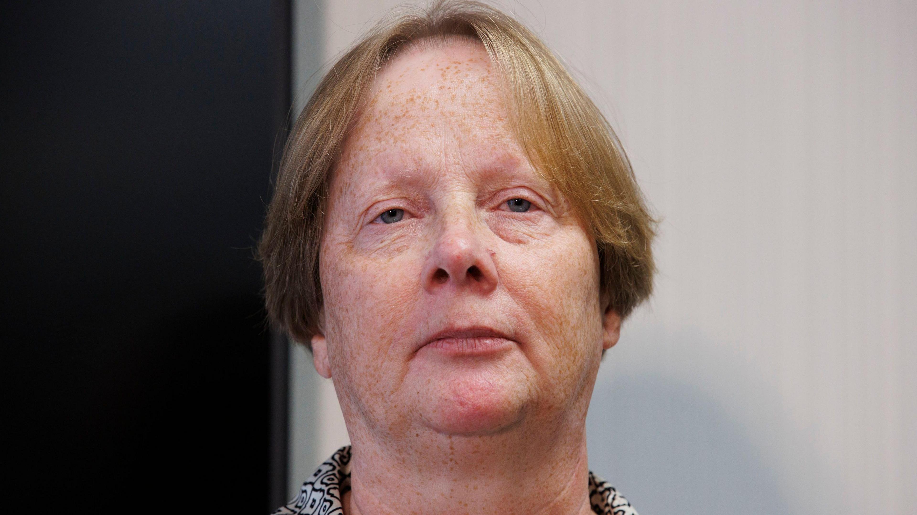 Elaine McCormill. She is an older woman with shortish, light-coloured hair. She is standing at the podium with a neutral expression on her face.