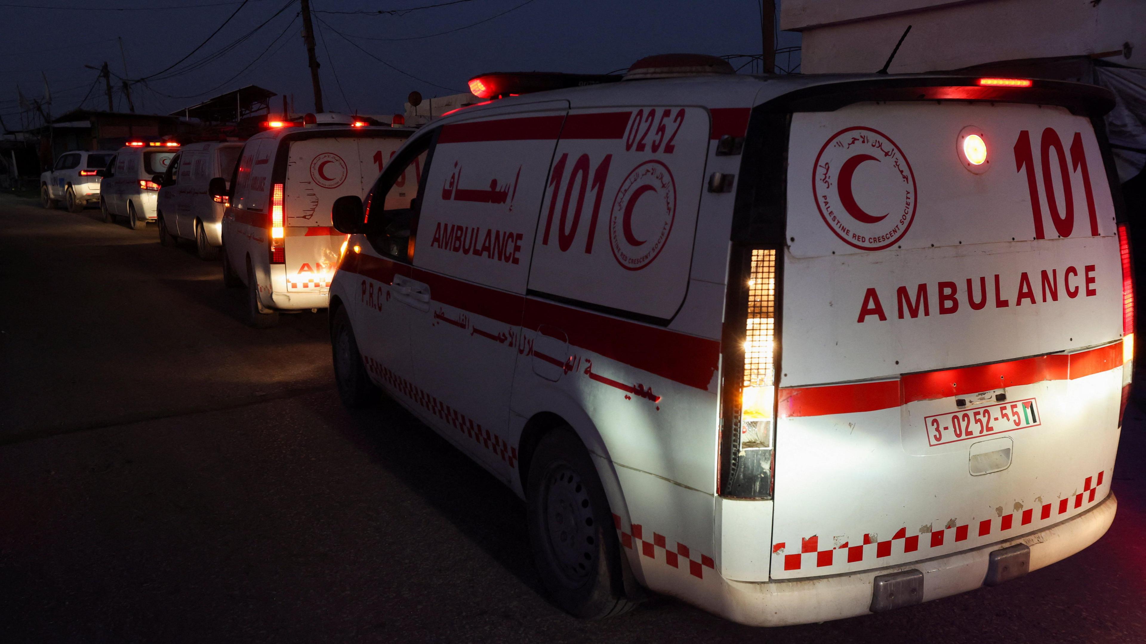 Red Crescent ambulances lined up behind one another in the dark