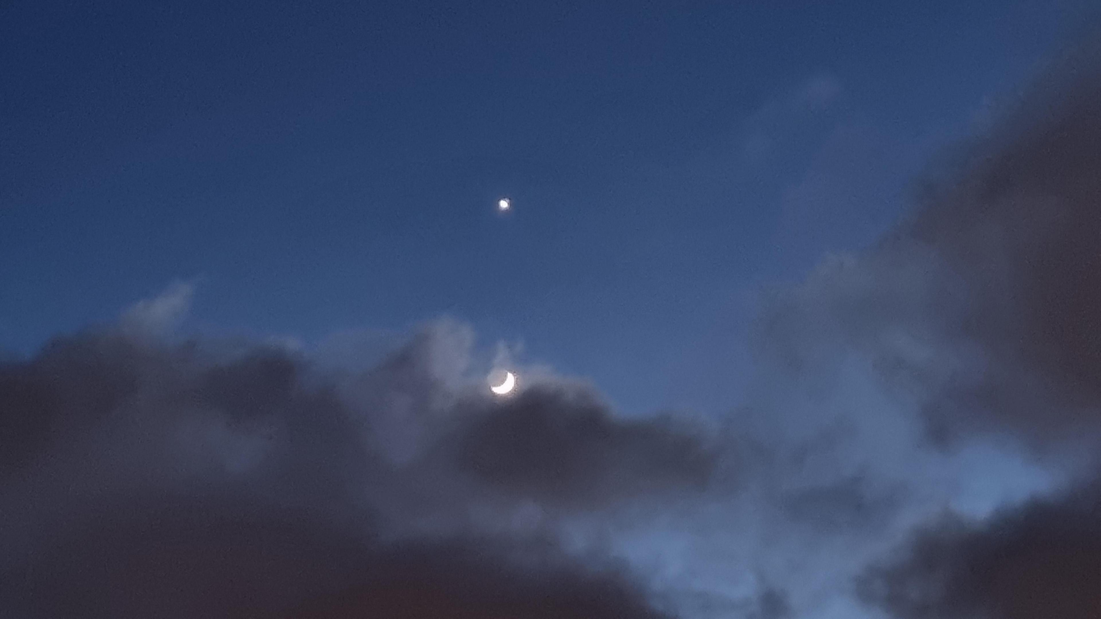 A cloud partially obscures the Moon, with Venus above.