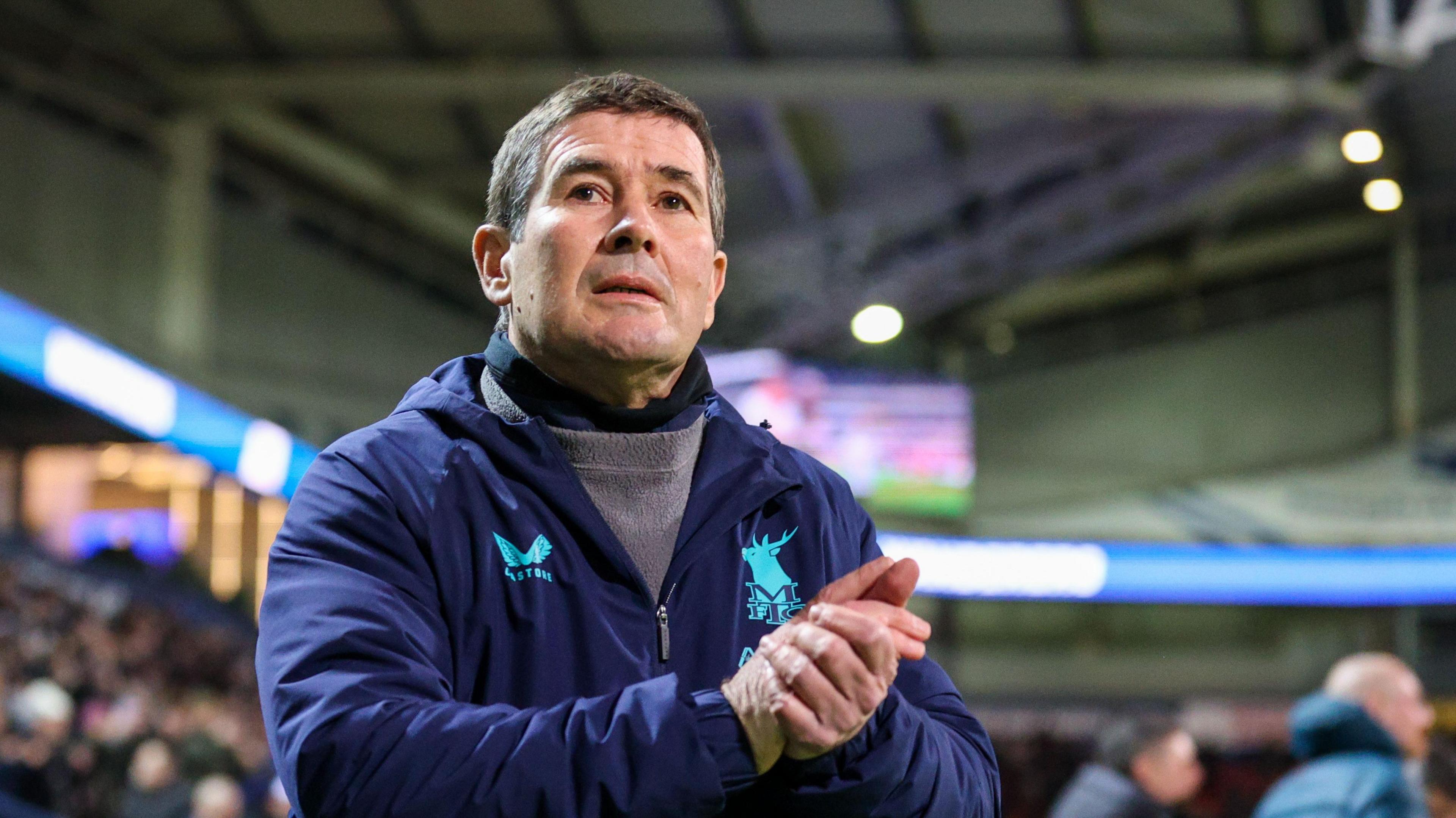 Mansfield boss Nigel Clough clasps his hands together