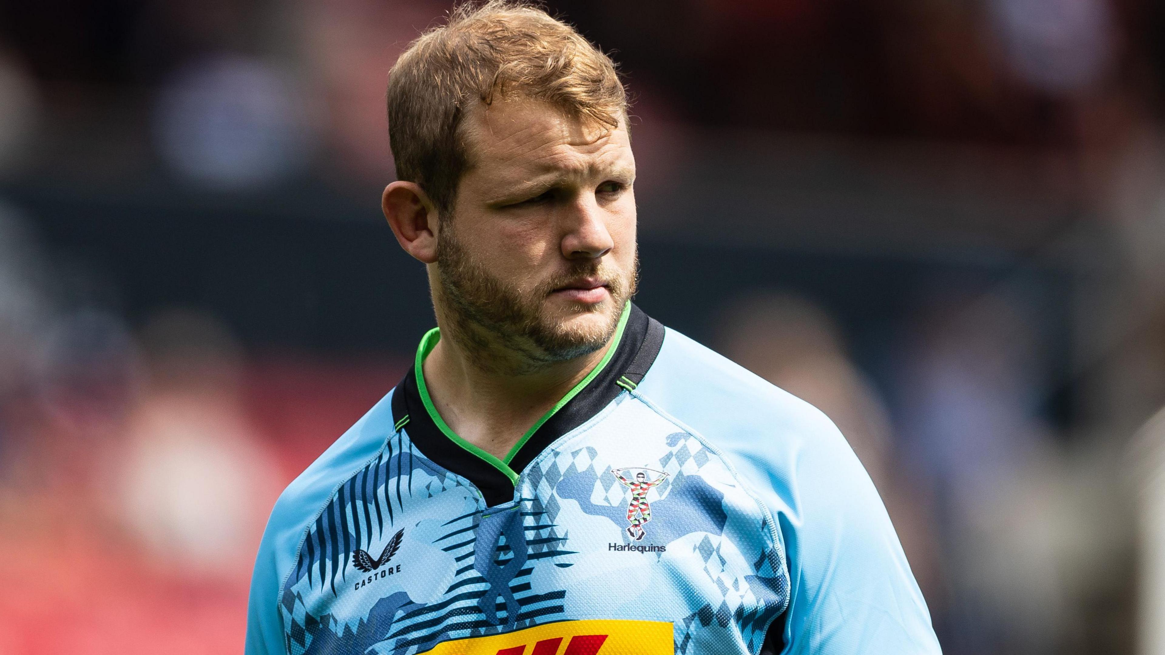 Joe Launchbury looks to his left during a match for Harlequins. He is wearing a sky blue coloured shirt.