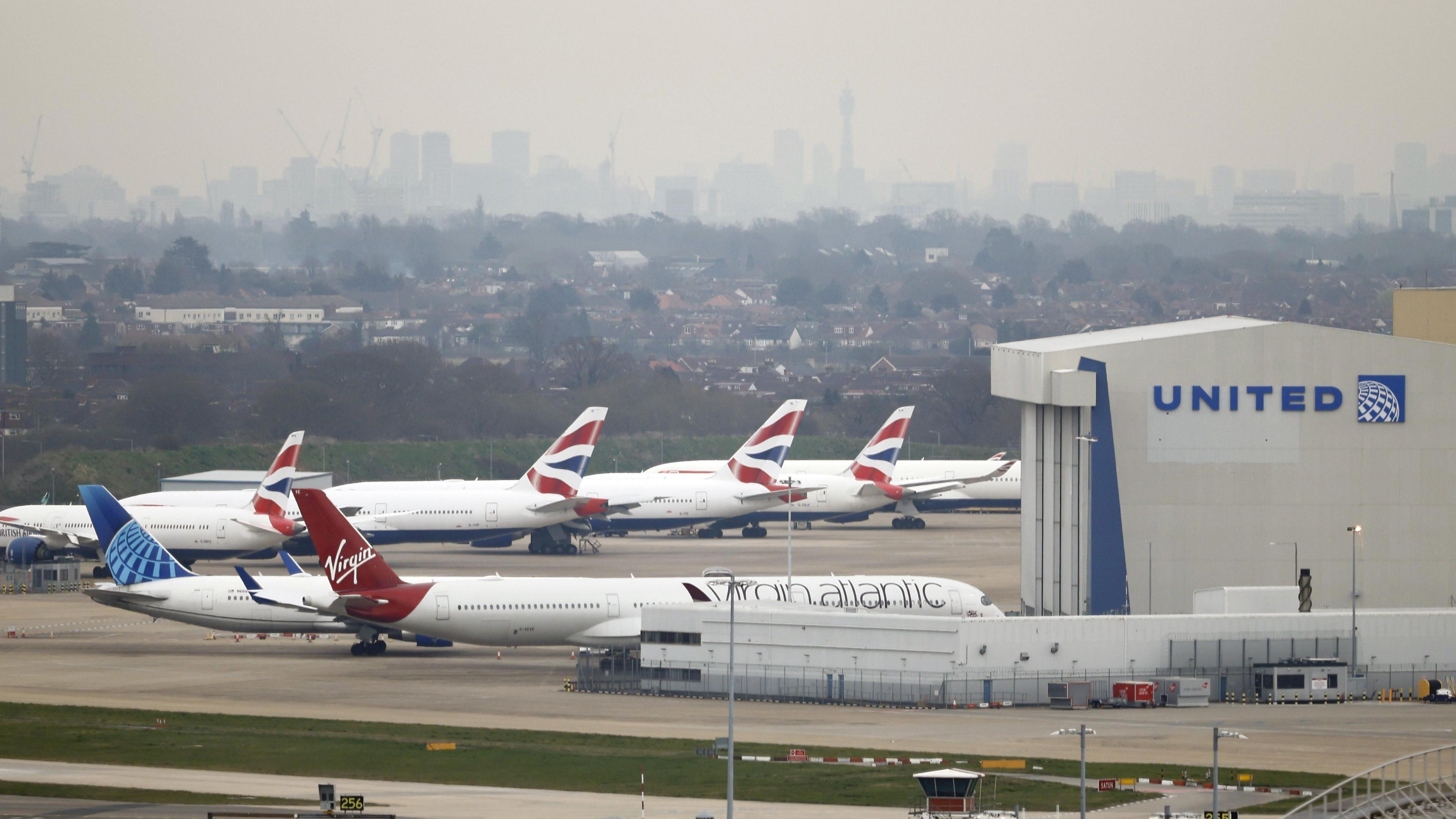 Planes on the runway at Heathrow airpot with London skyline in distance