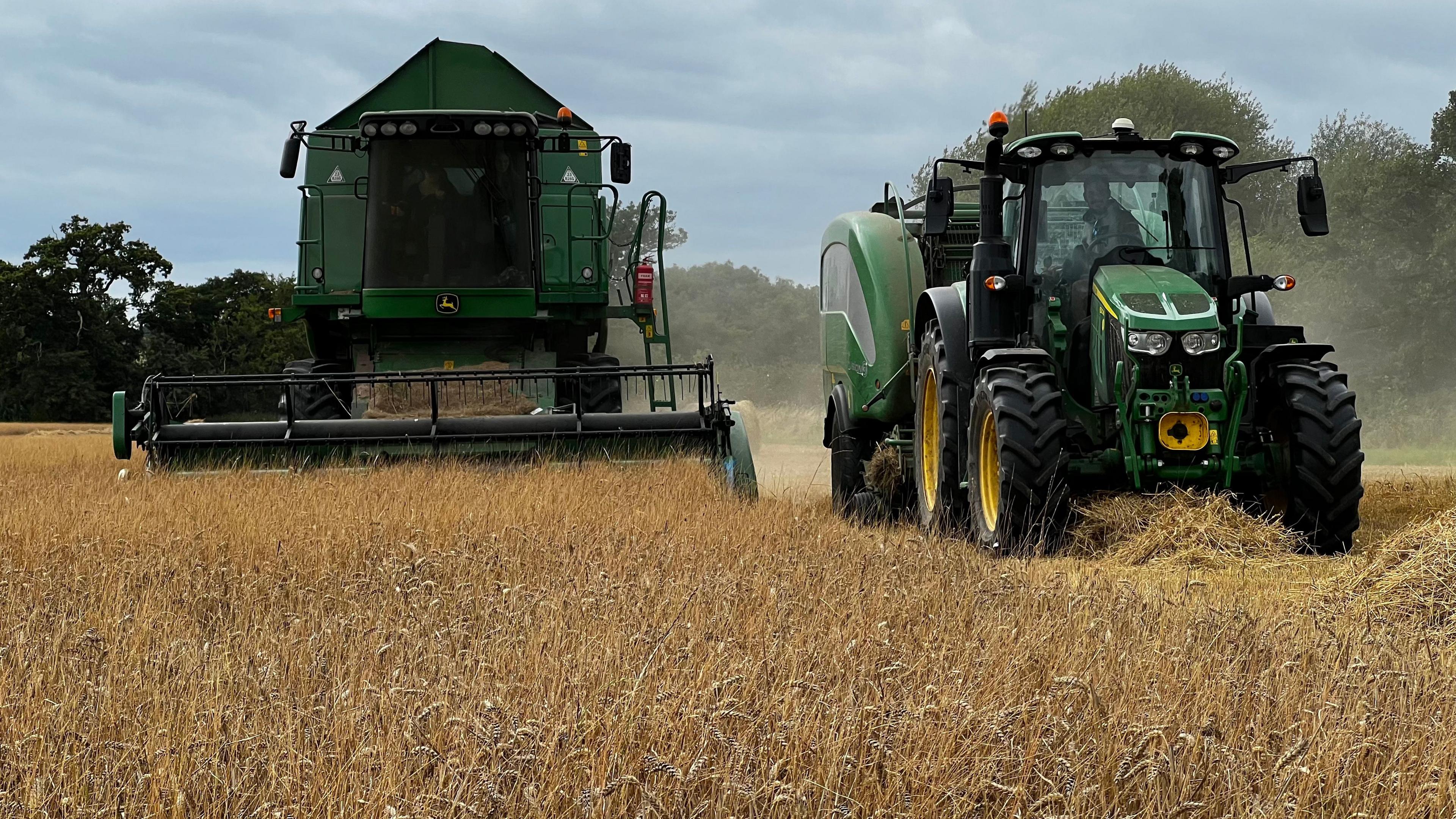 Tractor and combine harvester at work in a Somerset field