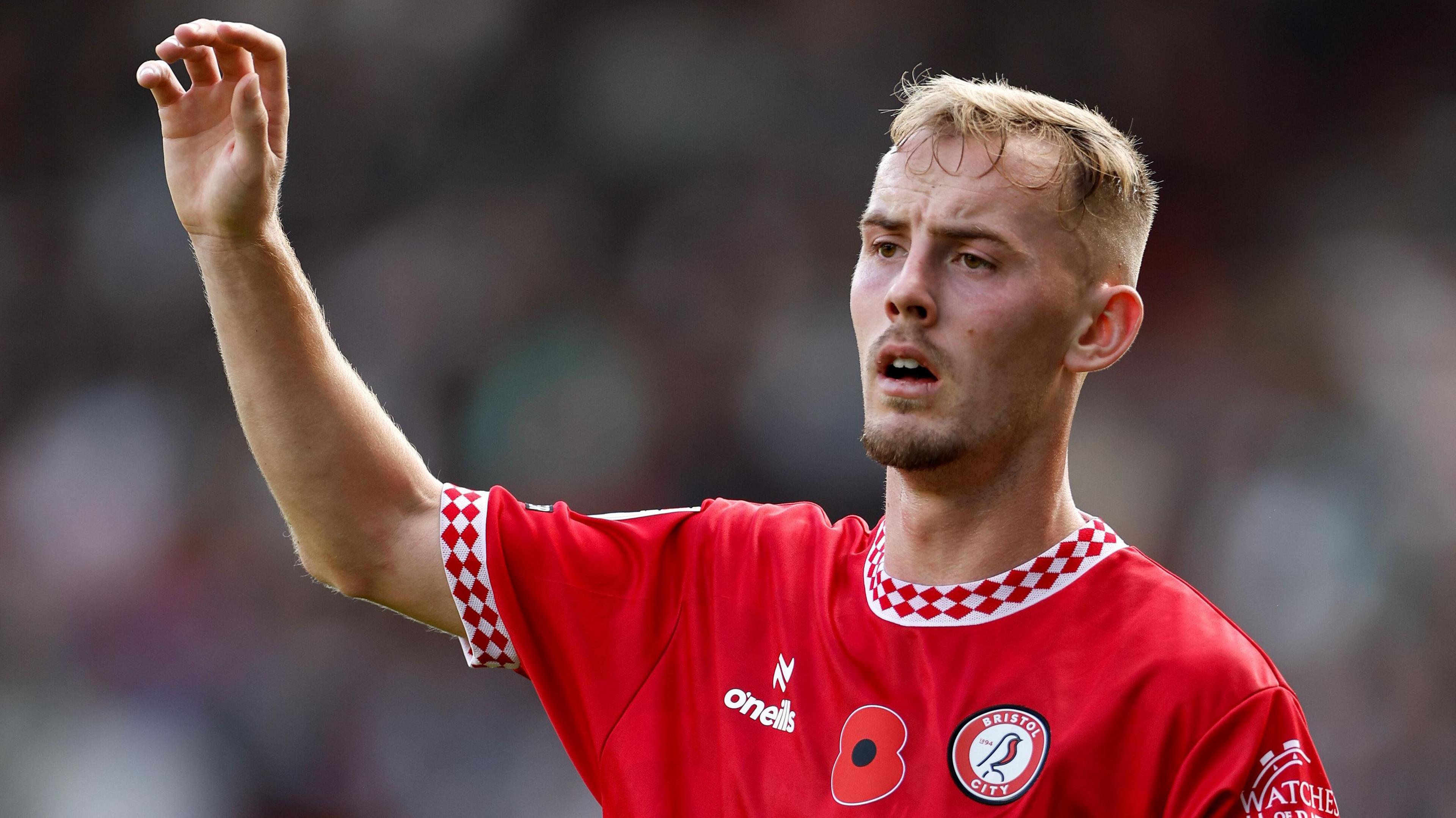 Mark Sykes holds his arm in the air on the field during a match