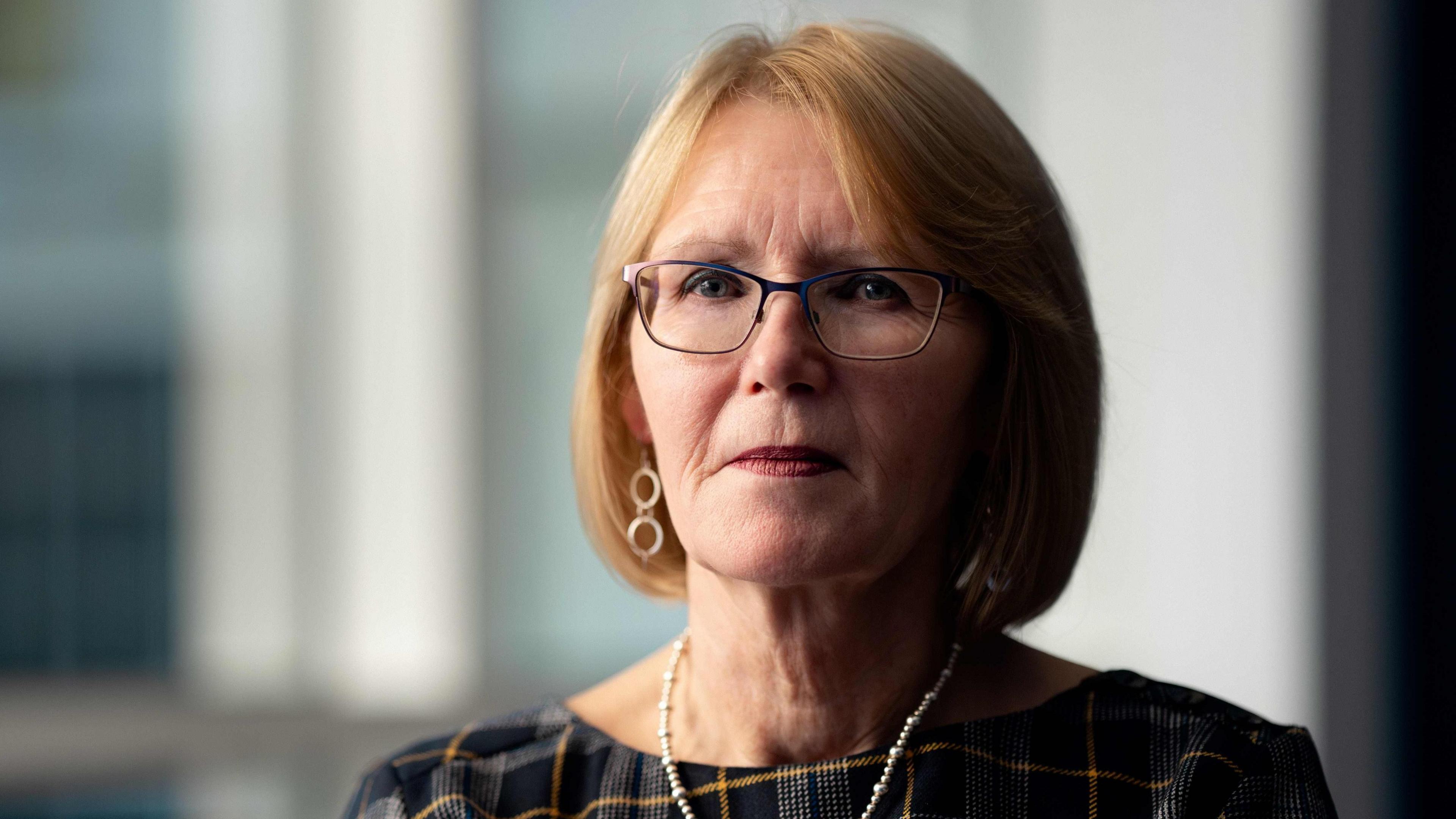 Teresa Medhurst, a woman with light coloured hair and glasses. She is wearing a 