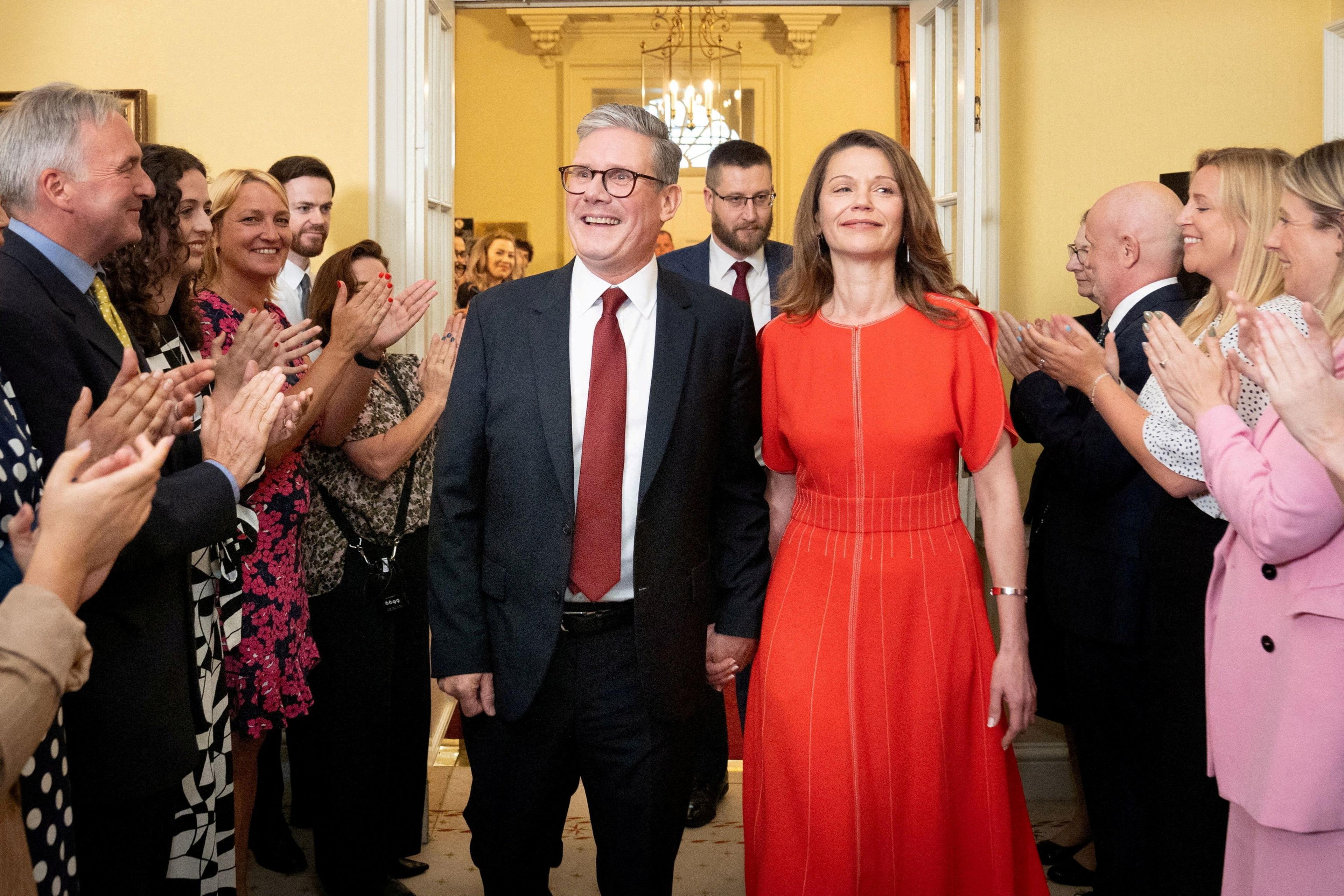 Sir Keir Starmer and his wife smiling amongst staff inside Downing Street