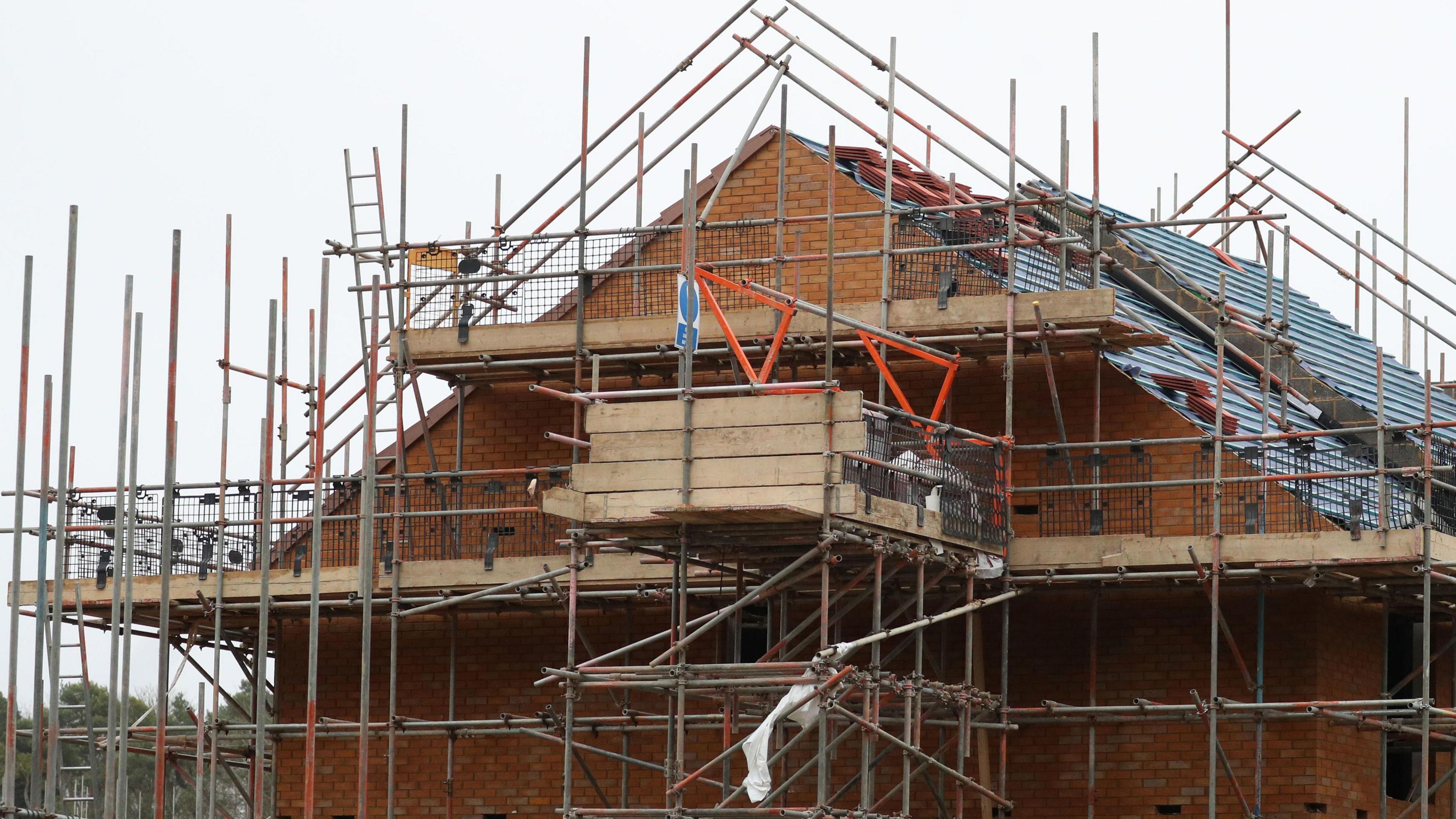 A part built house covered in scaffolding