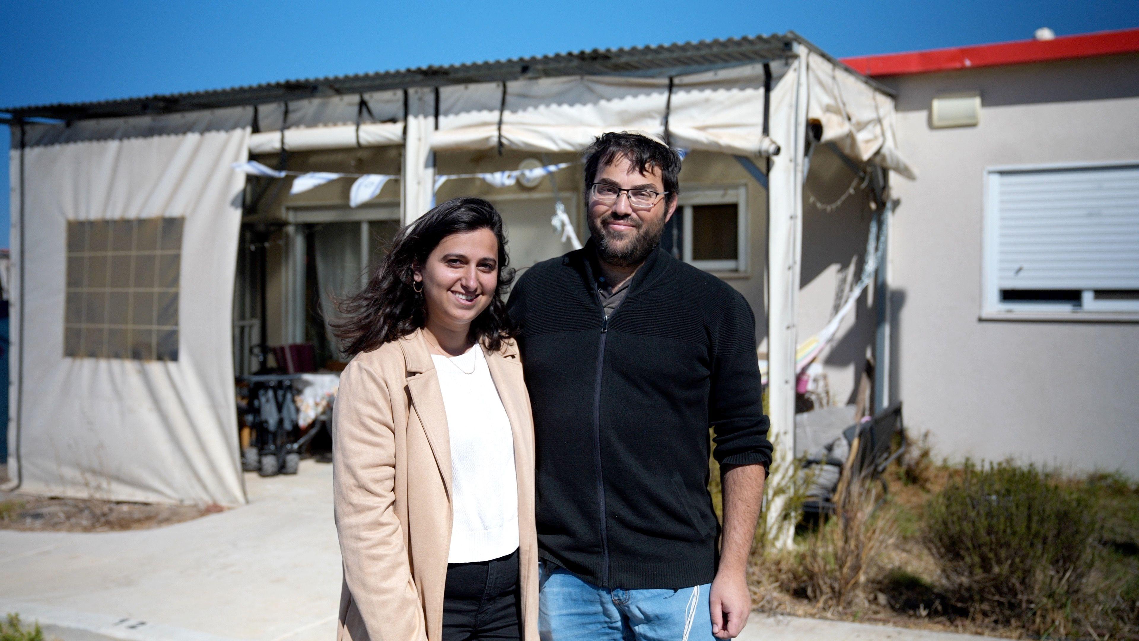 Elik Goldberg and his wife Hodaya standing outside the front of their home