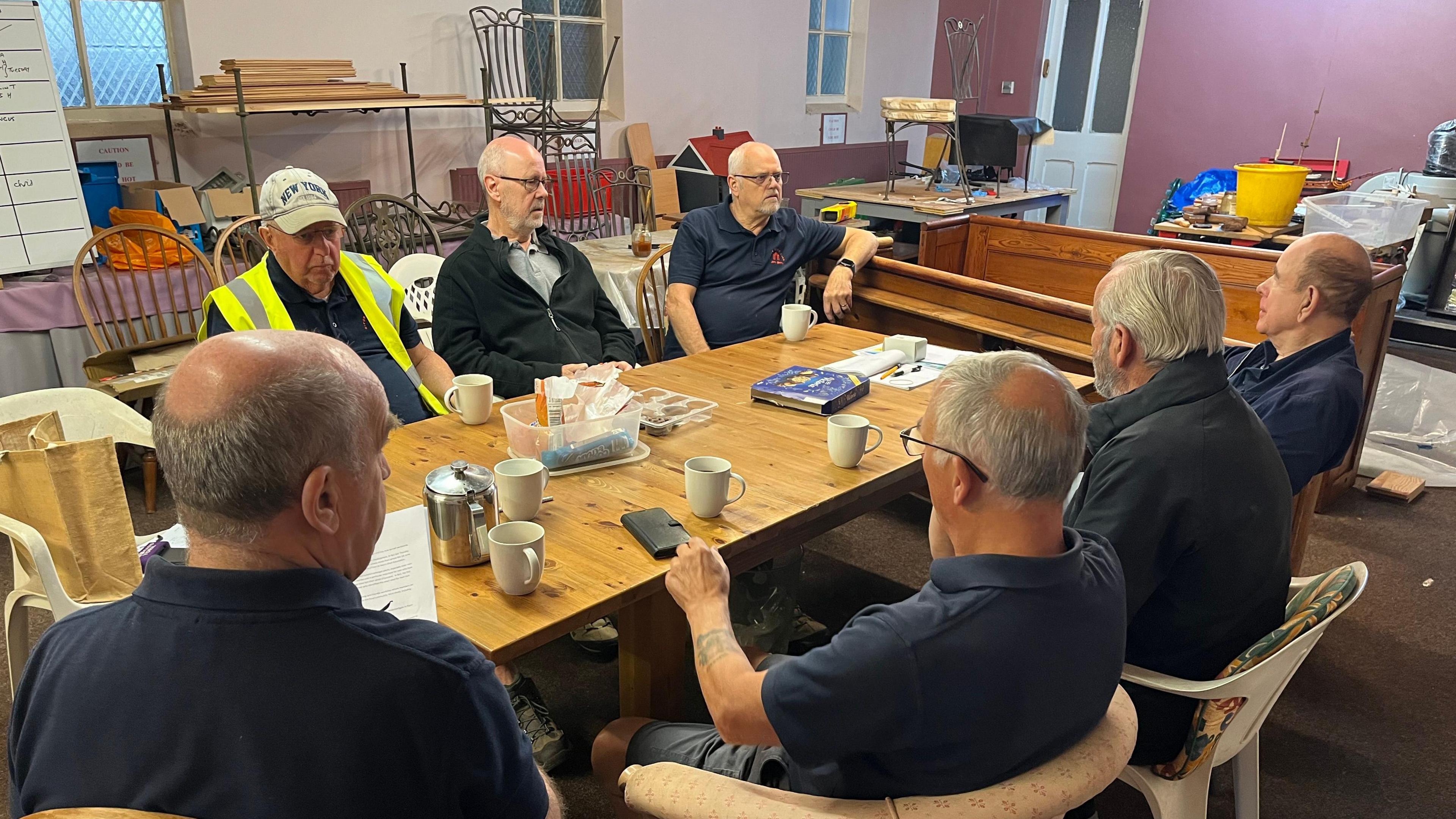 Group of men around a table drinking tea