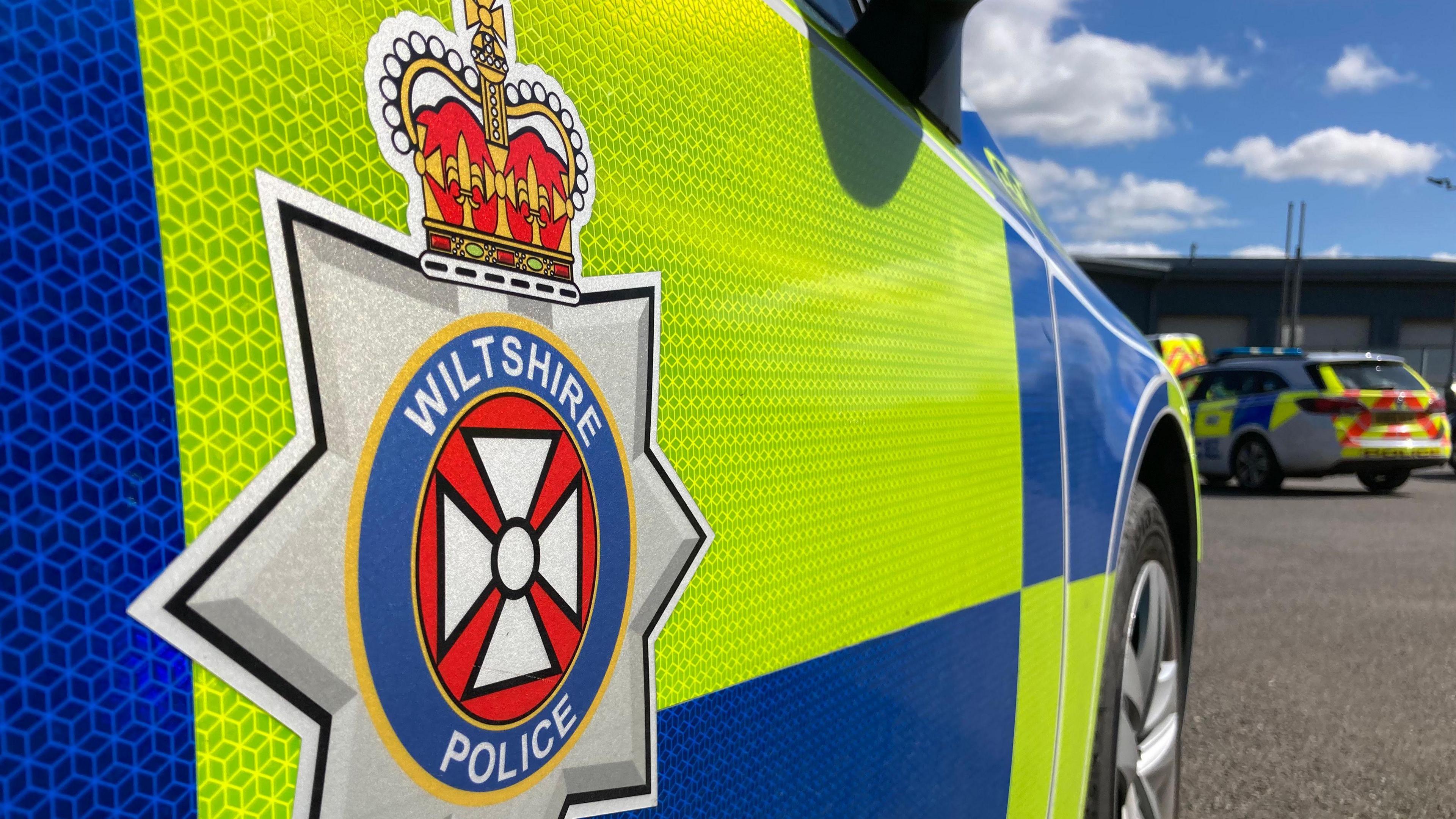 Close-up of the side of a Wiltshire Police car, showing the force logo