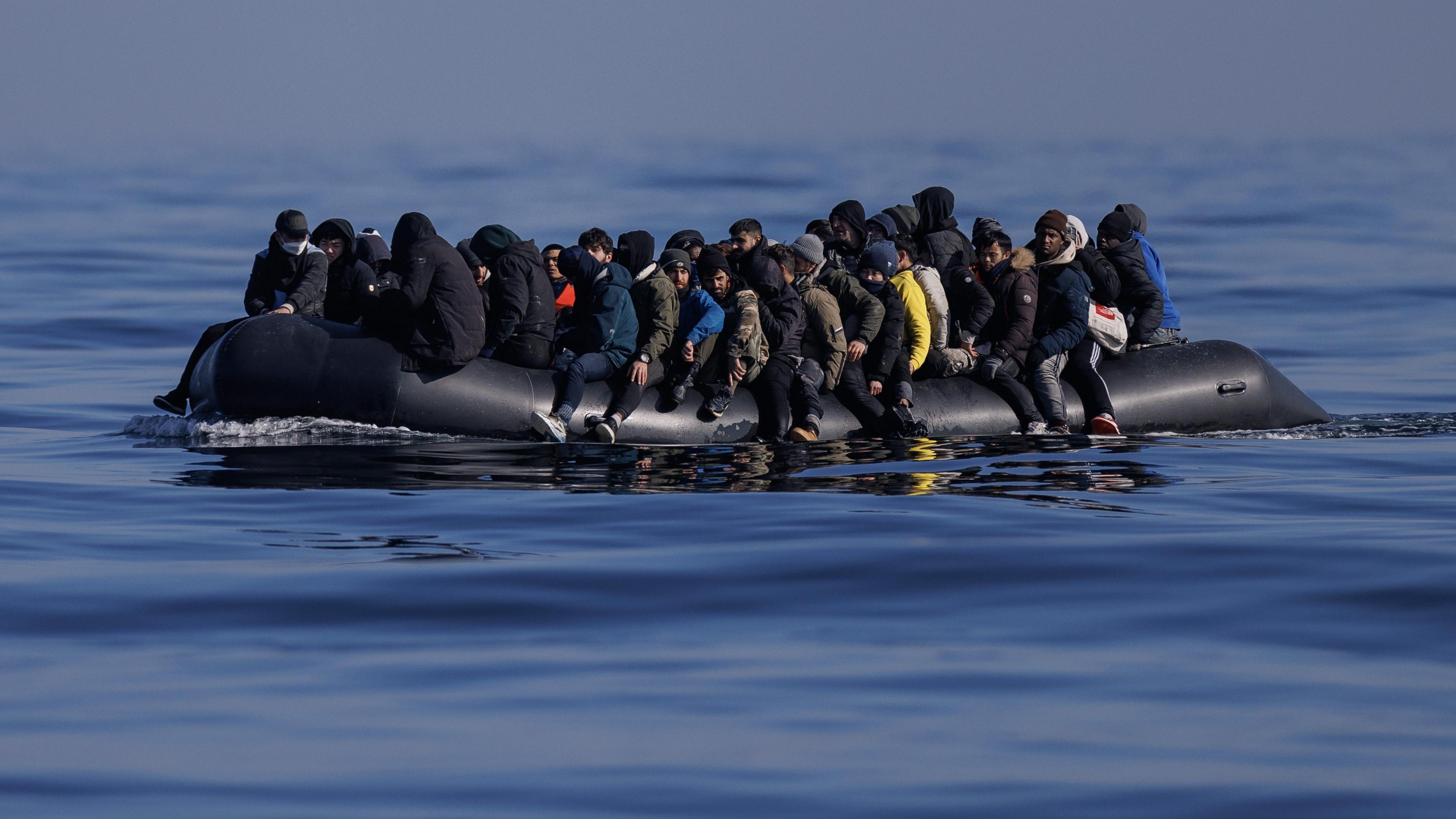 An inflatable dinghy carrying around 65 migrants crosses the English Channel