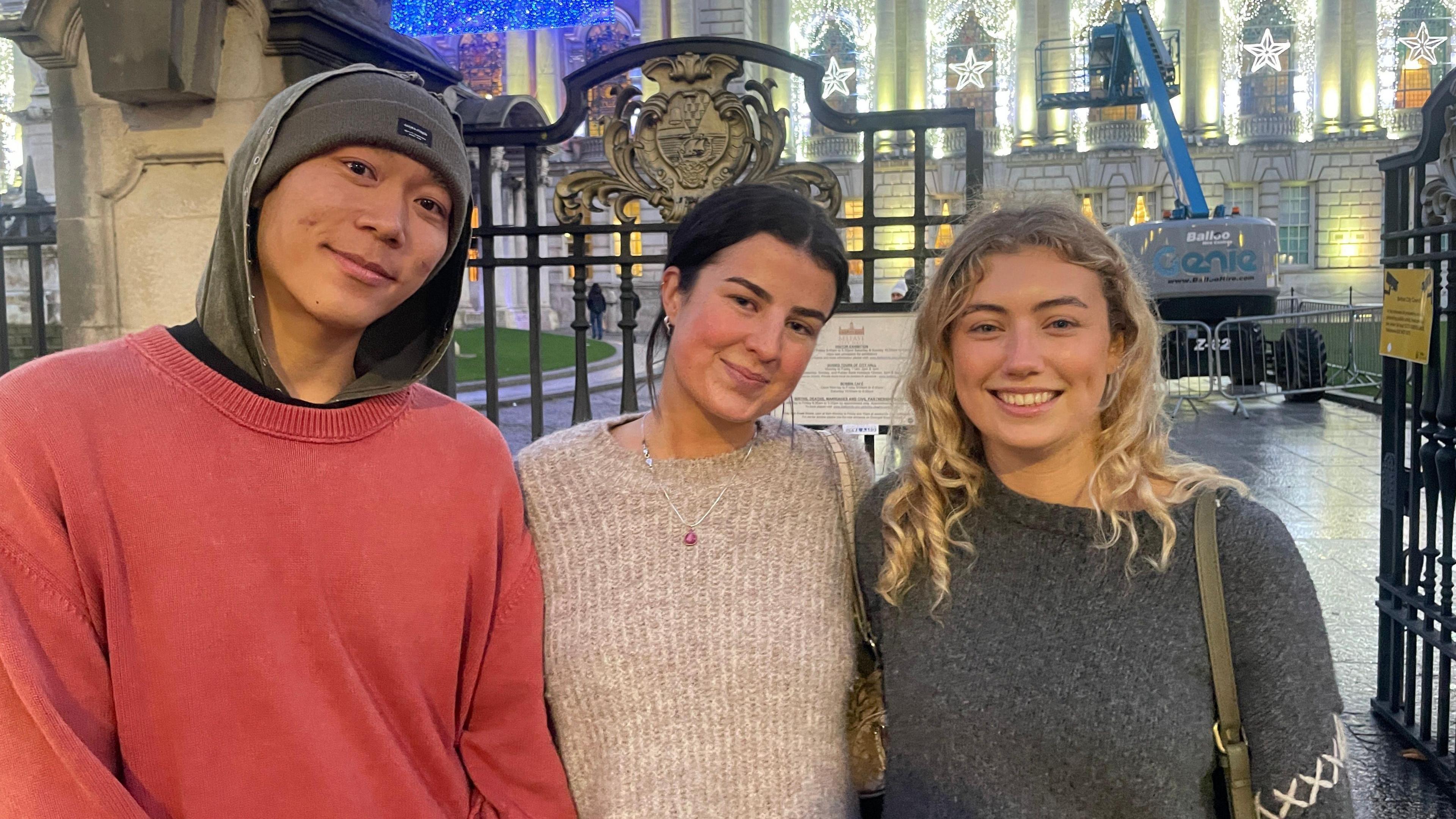 Kevin Wong wears a pink jumper. Erin Grant wears a cream jumper and has brown hair tied back. Sabine Doran wears a grey jumper and has blonde curly hair.