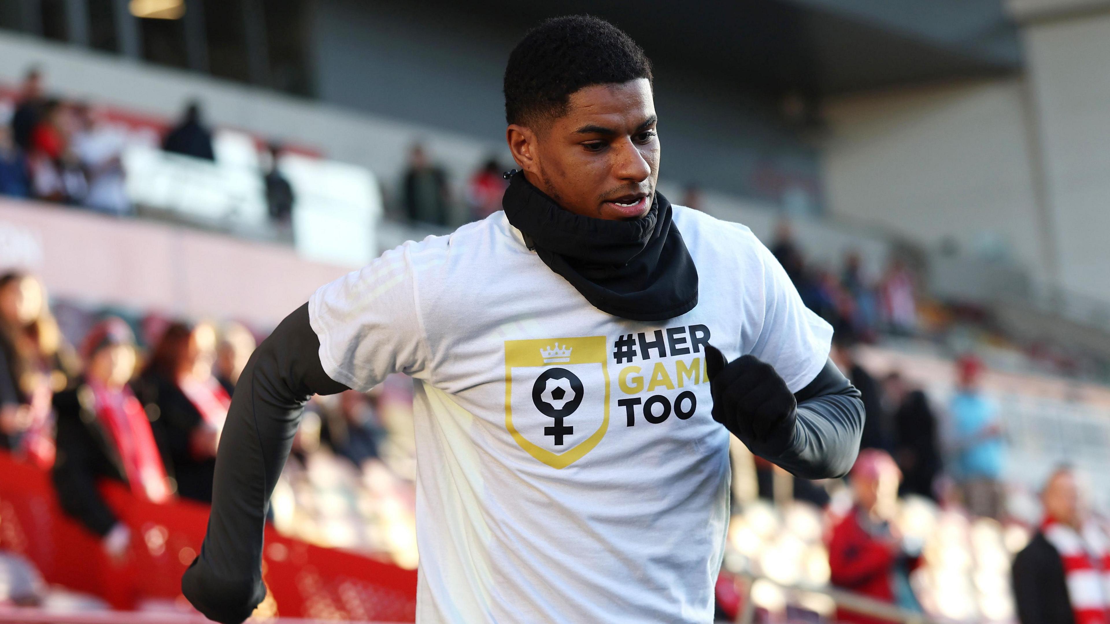 Marcus Rashford showing his support for campaign group Her Game Too by wearing a T-shirt showing their logo