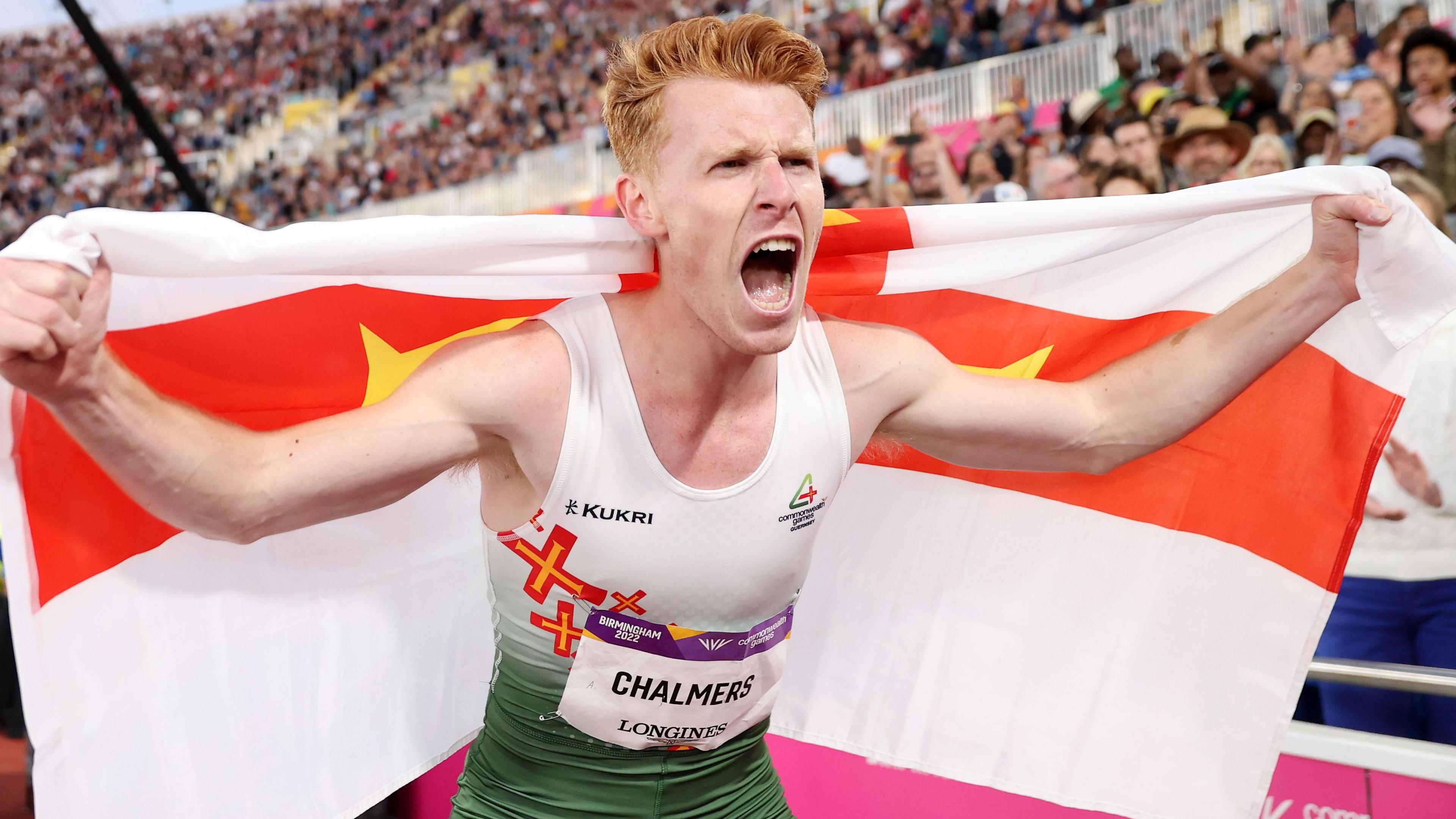 Alastair Chalmers celebrates holding a Guernsey flag