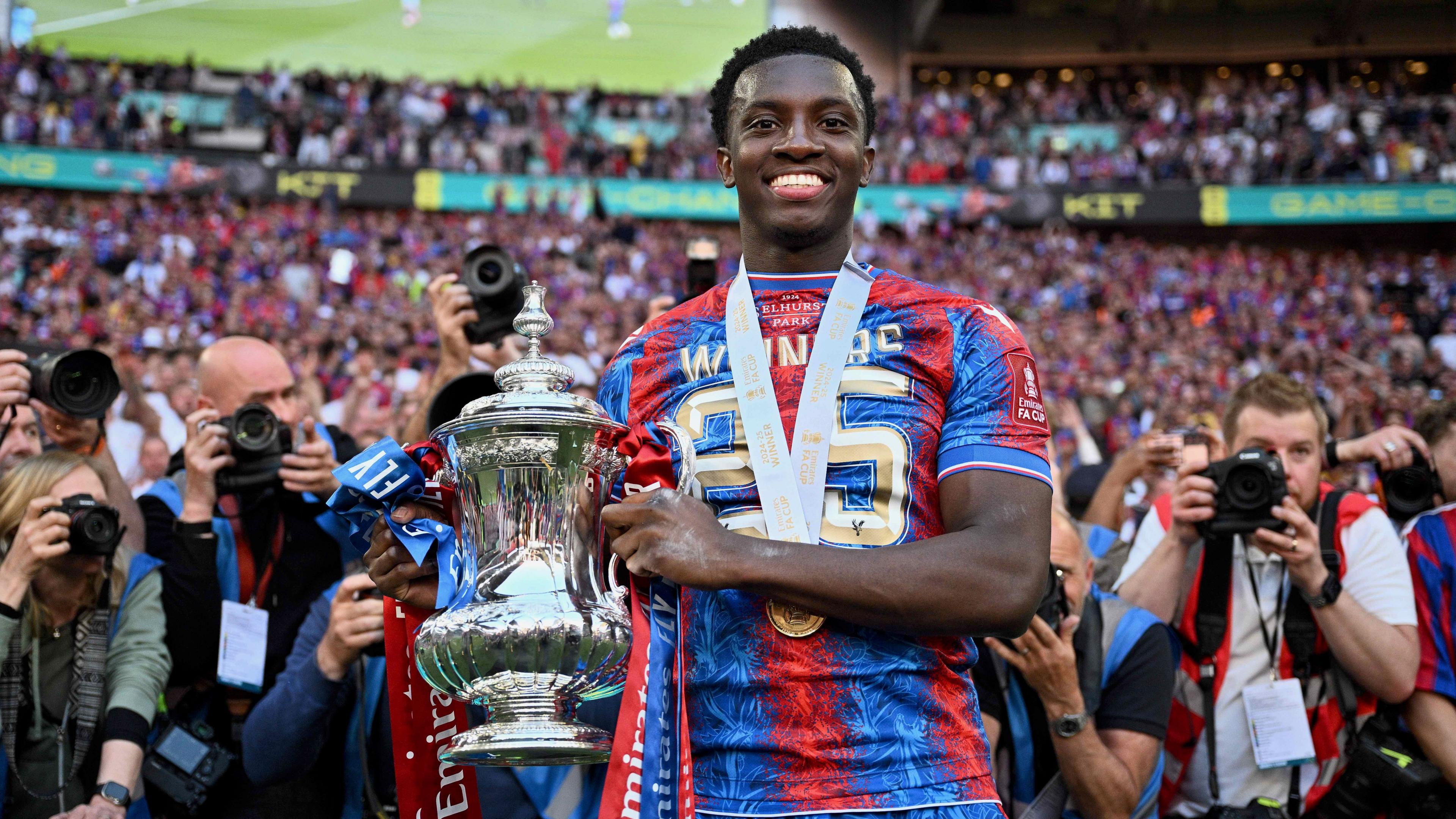 Eddie Nketiah holds the FA Cup and smiles