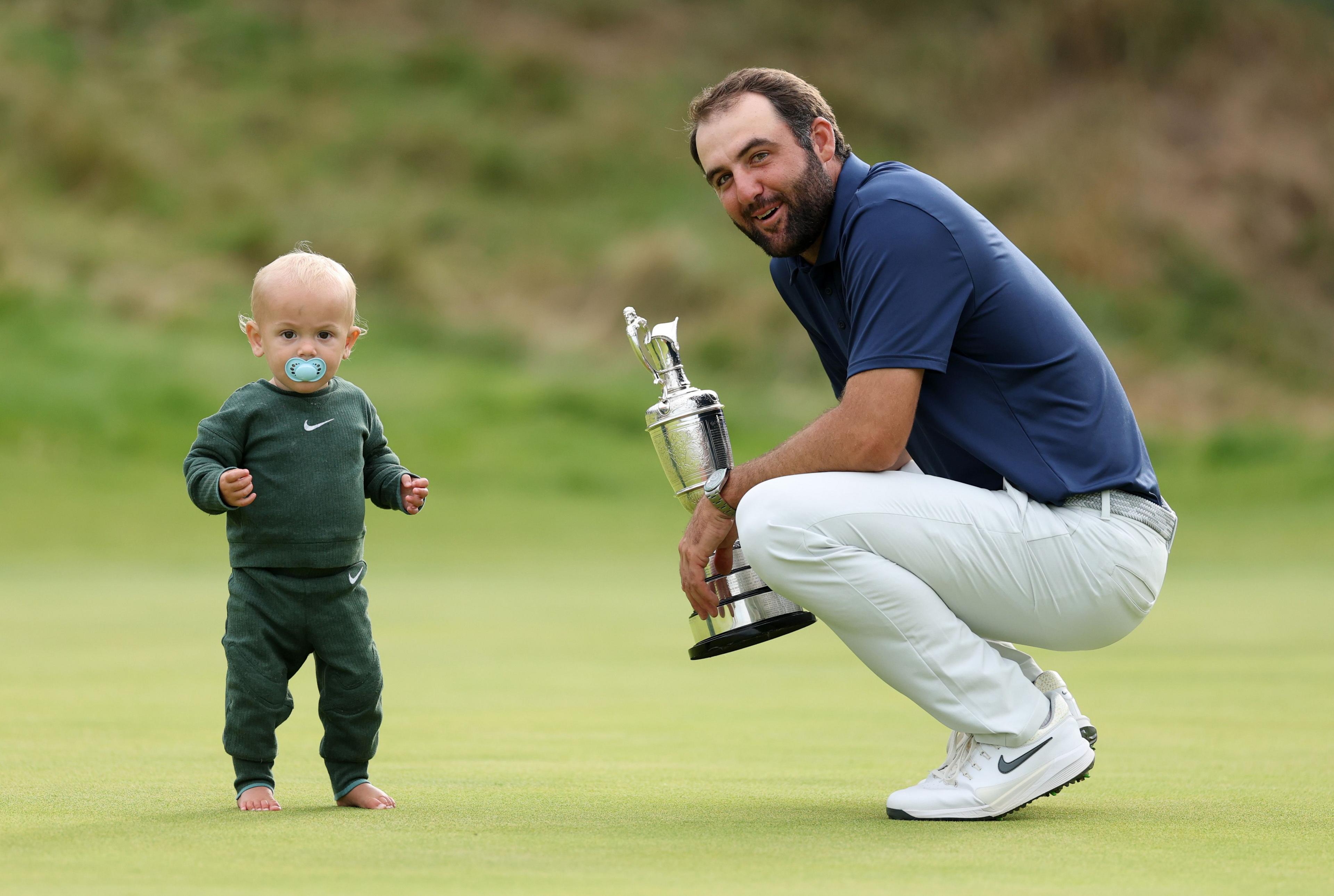 United States' Scottie Scheffler celebrates with his son Bennett Scheffler and the Claret Jug on the 18th green after winning The 153rd Open Championship at Royal Portrush Golf Club in Northern Ireland. Photo by Christian Petersen