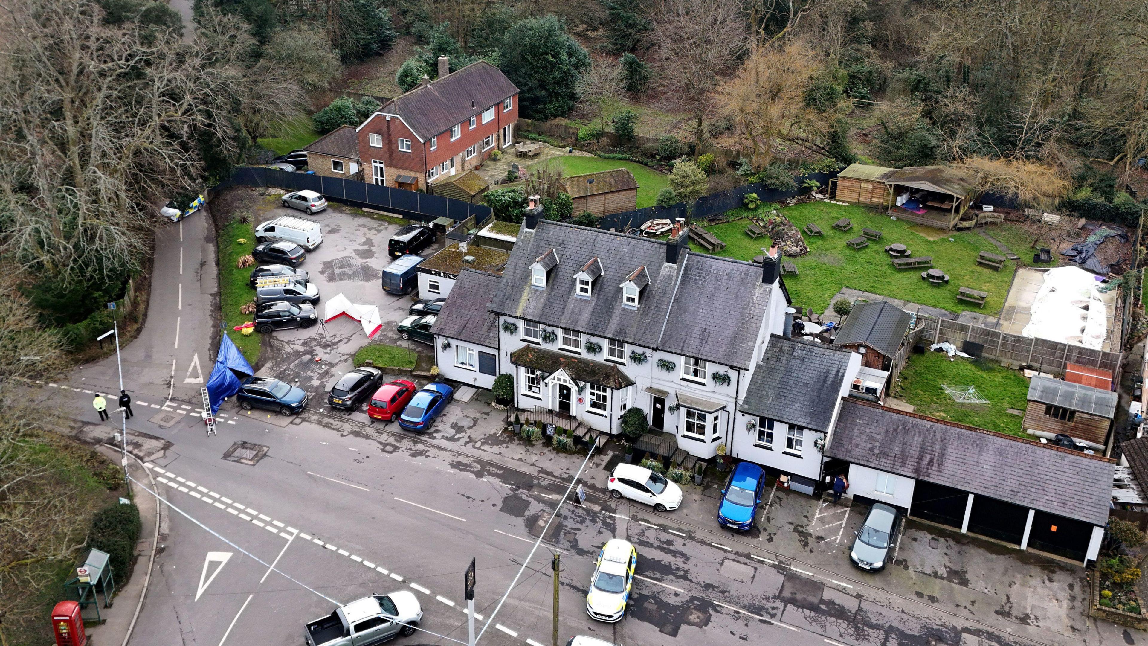 A white pub is seen from above. Its garden is visable in the background. 