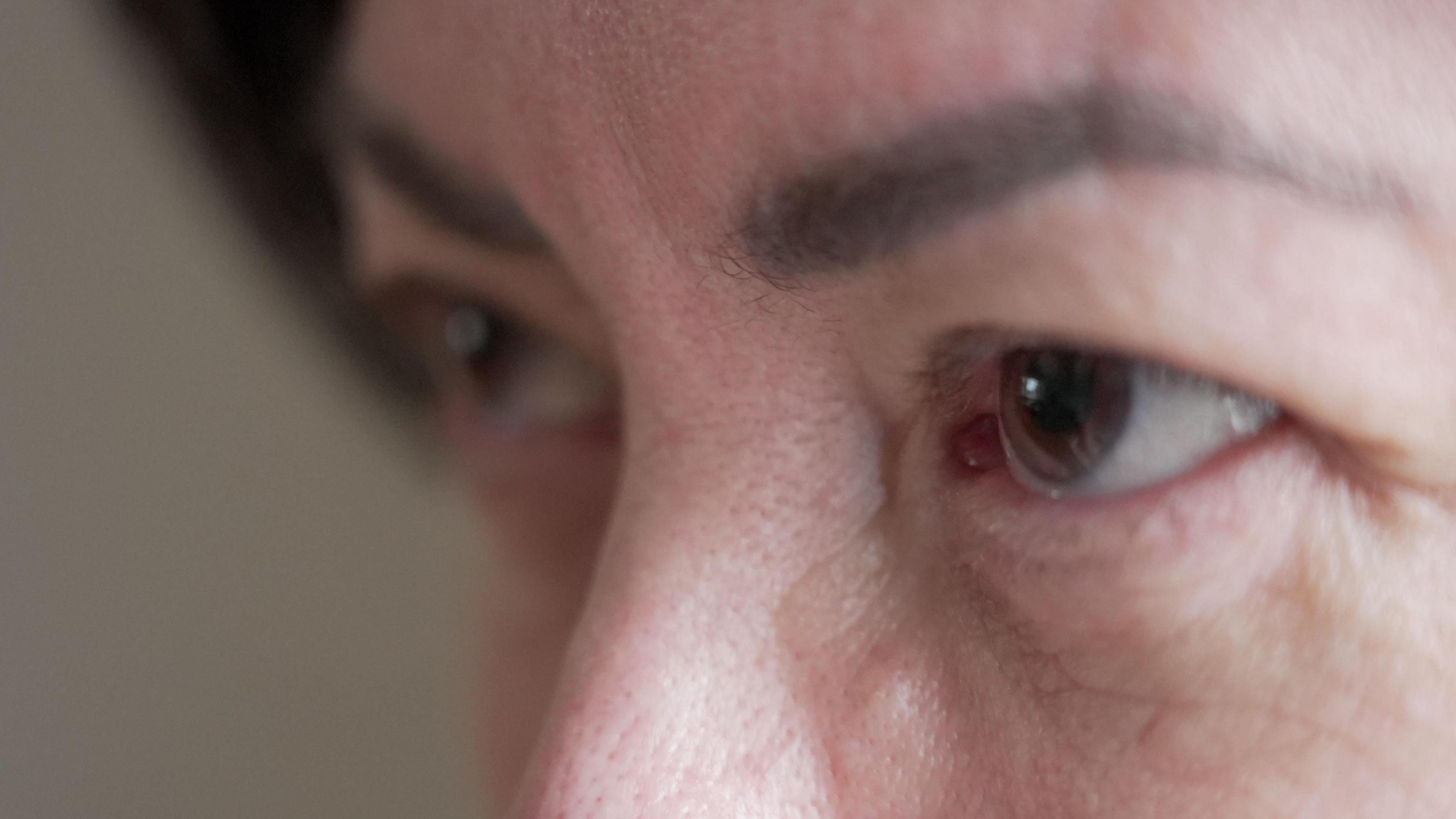 A close up shot of a woman's face, showing just her eyes, eyebrows and top of her nose. She has dark, arched eyebrows and brown eyes. 