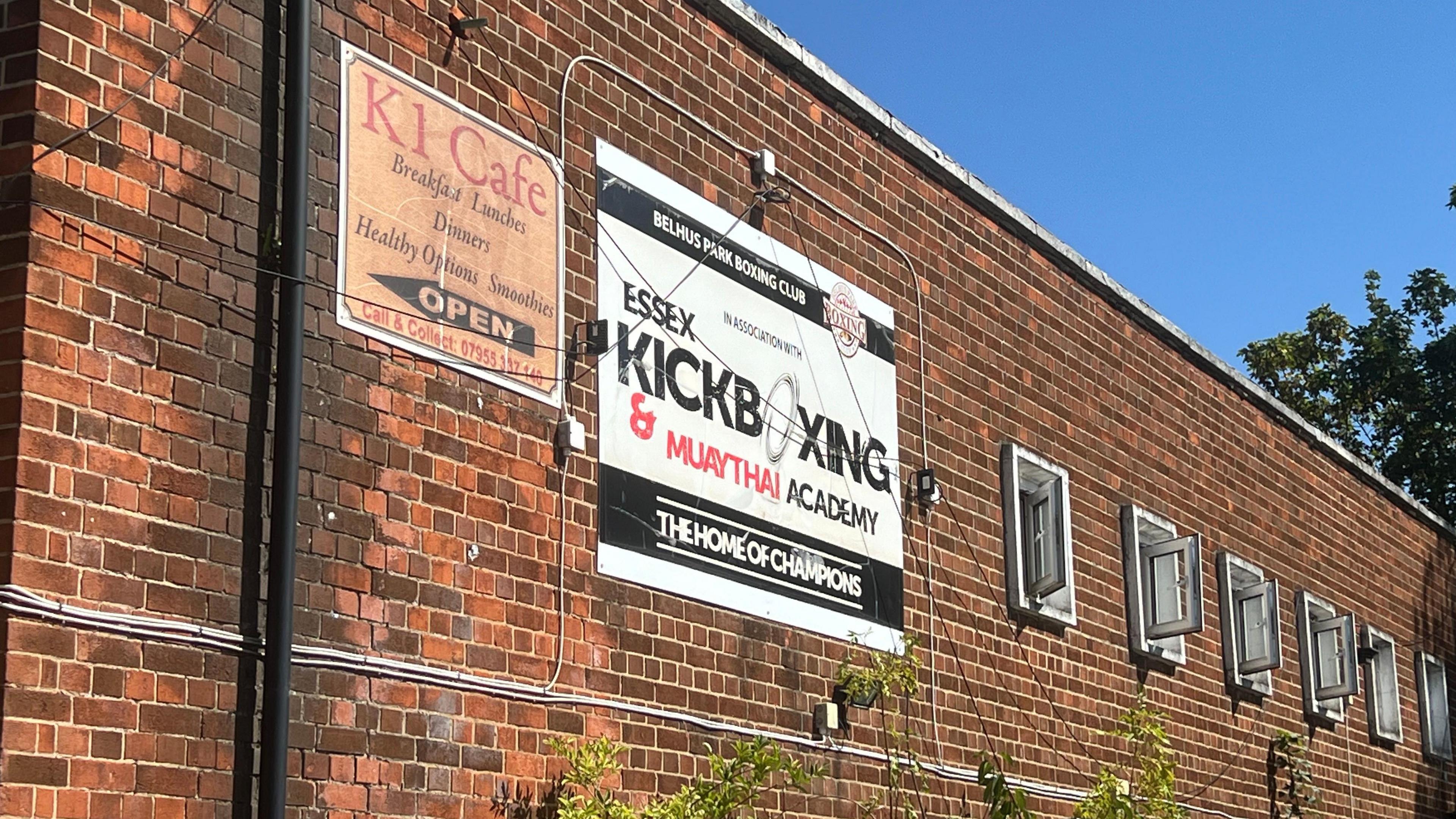 A black and white sign reads "Essex Kickboxing & Muay Thai Academy, The Home of Champions"