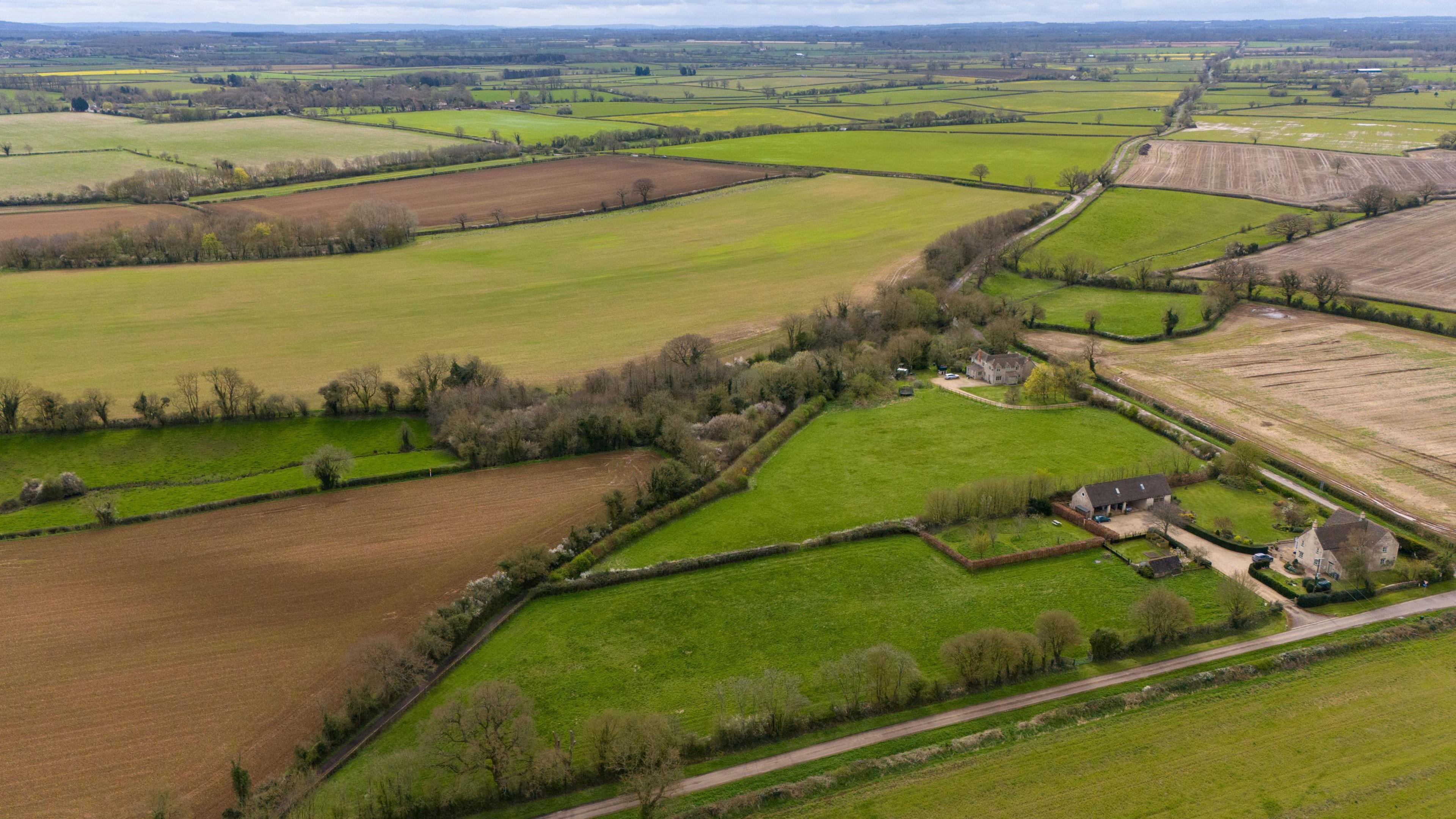 A view looking towards the proposed Lime Down solar farm site with the old Roman road, going diagonally through the landscape into the distance, in the Wiltshire countryside near Malmesbury and Sherston