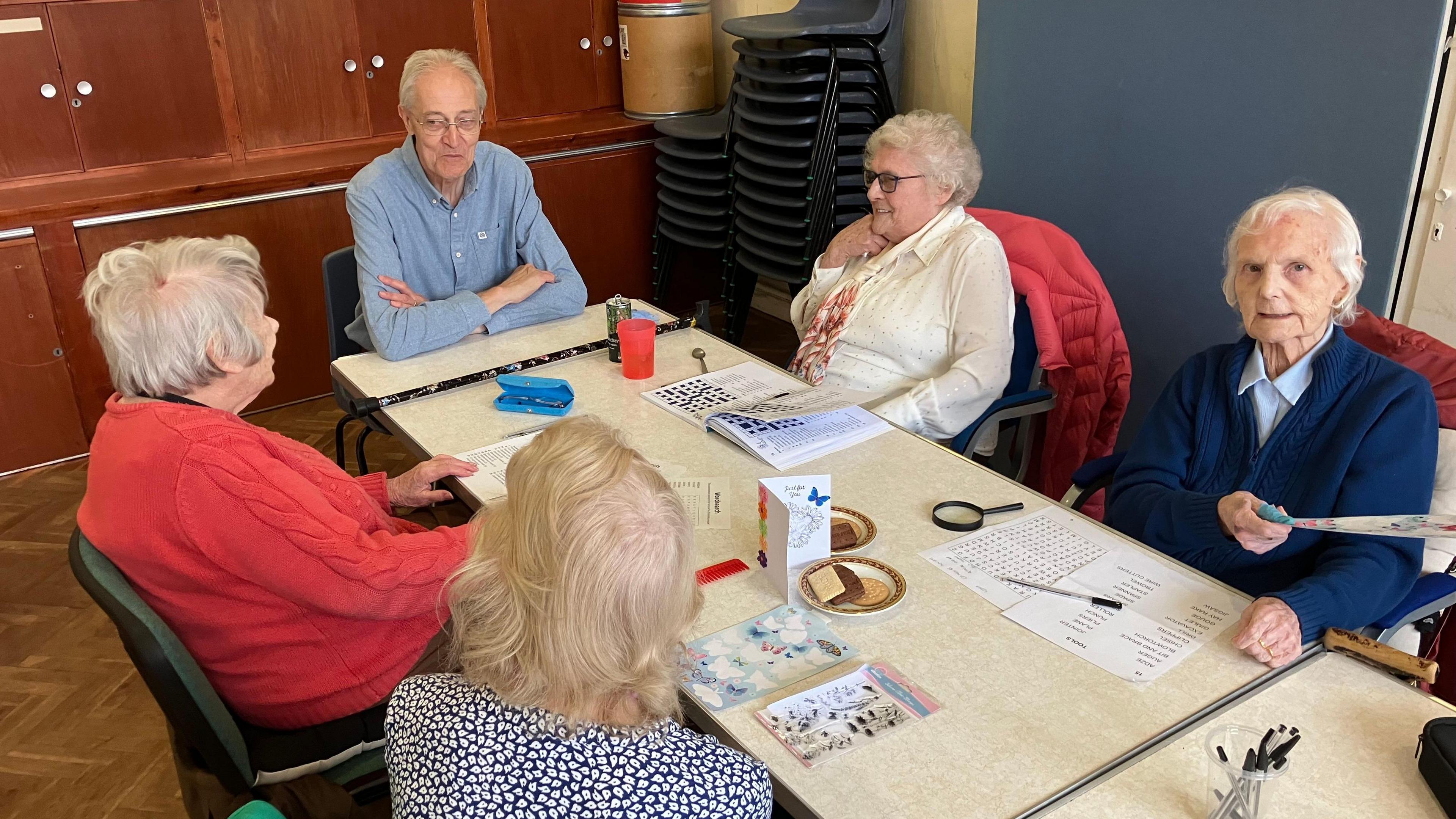 A group of older people are pictured around a table at one of the day clubs