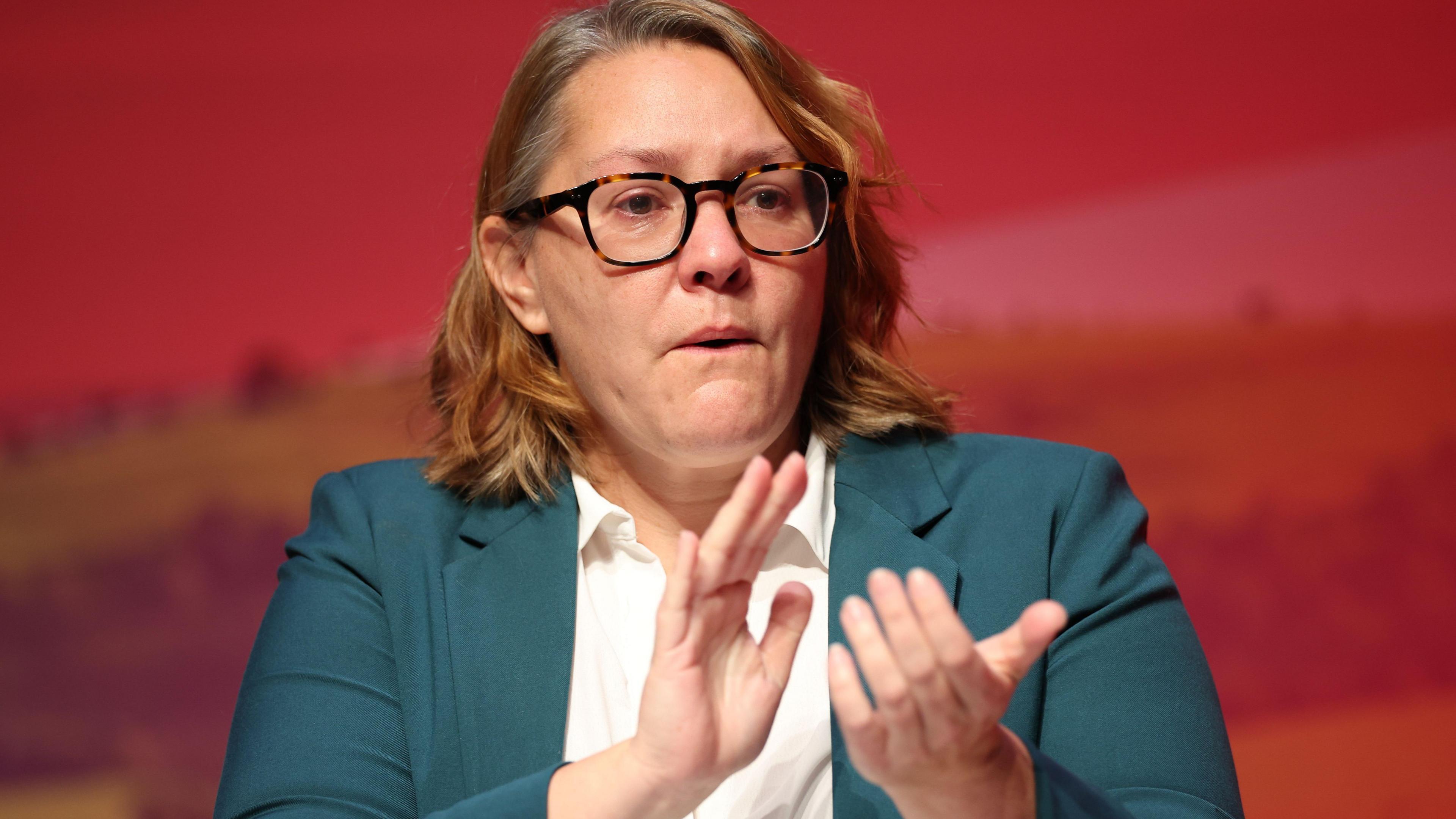 Anna Turley at the Labour Party Conference in September 2025. She has shoulder-length brown hair and is wearing glasses. She is wearing a blue suit and white shirt.