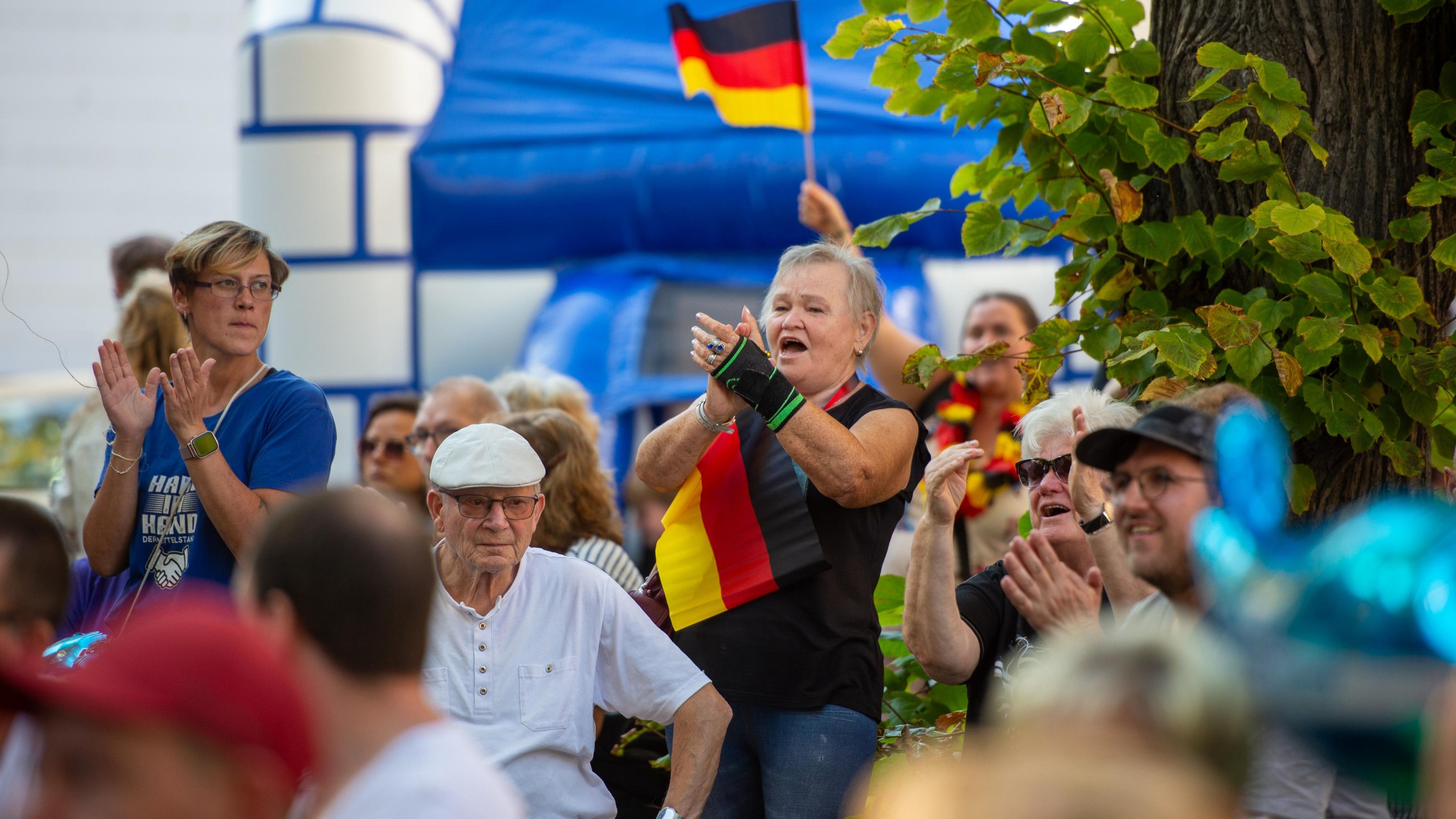 Woman cheers at rally with German flag