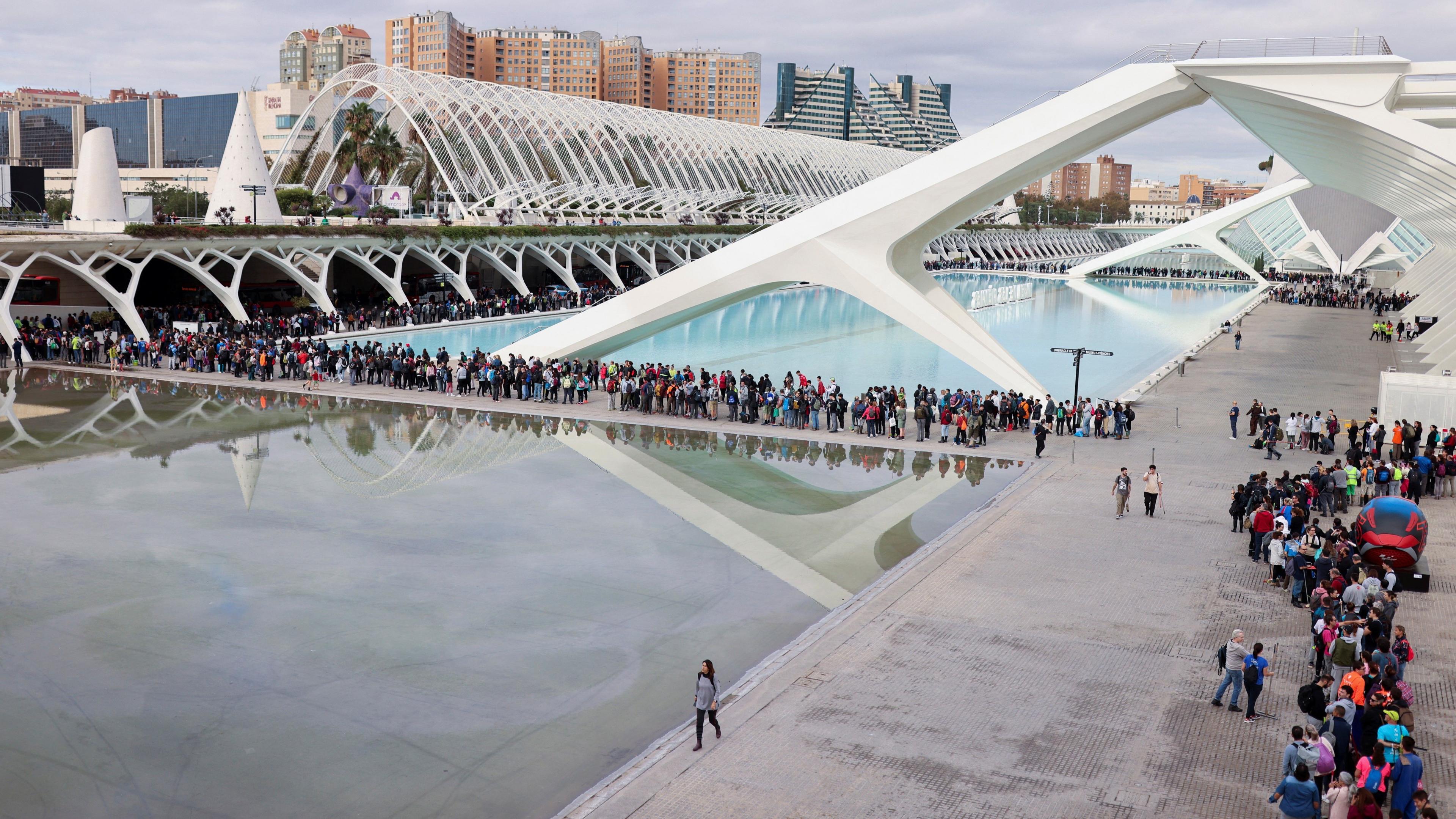 An aerial view shows queues of volunteers snaking around buildings and a body of water at the Ciudad de las Arts y las Ciencias in Valencia, Spain